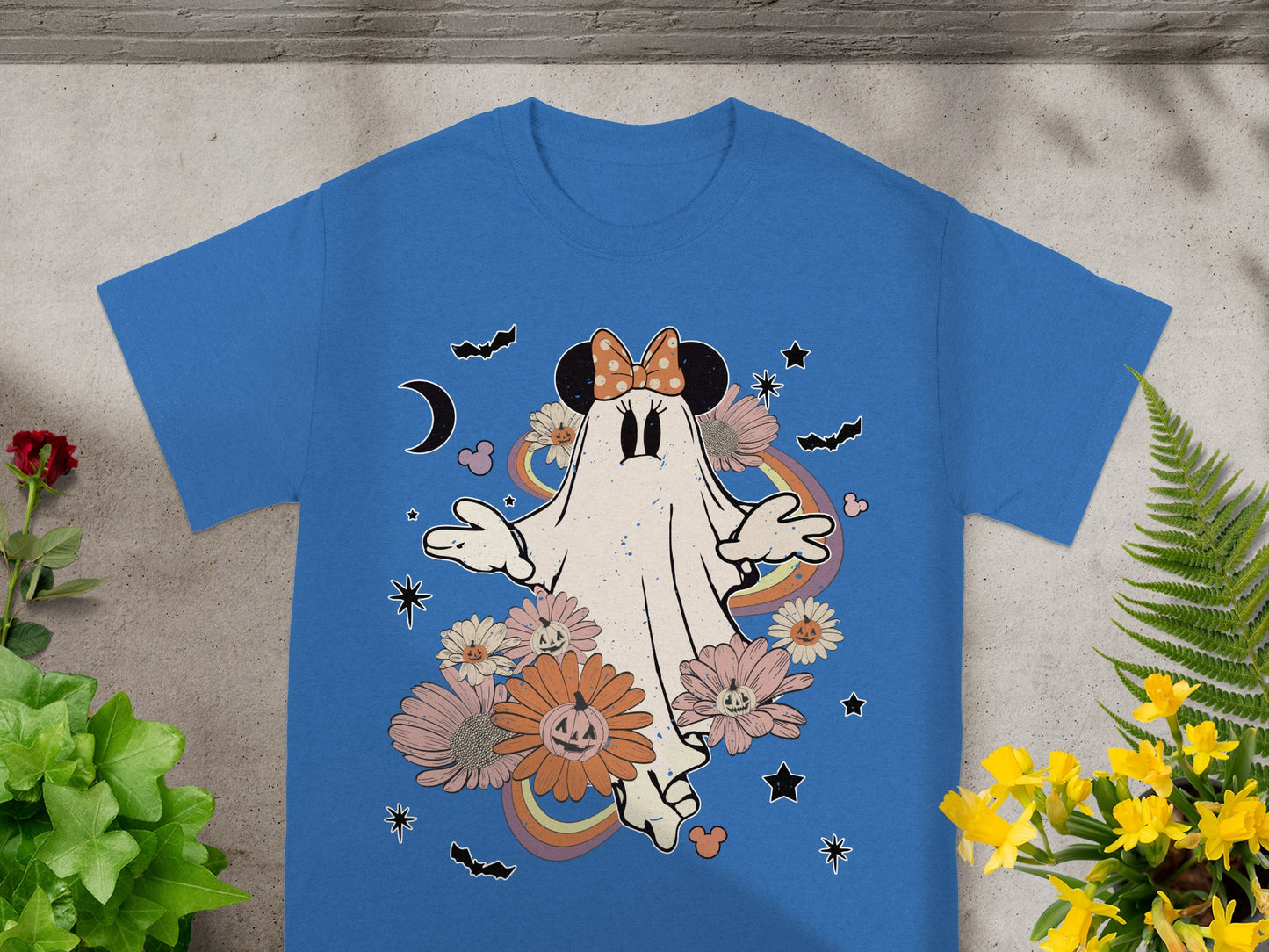 Blue t-shirt with a ghost character wearing a Minnie Mouse bow, surrounded by flowers and bats.