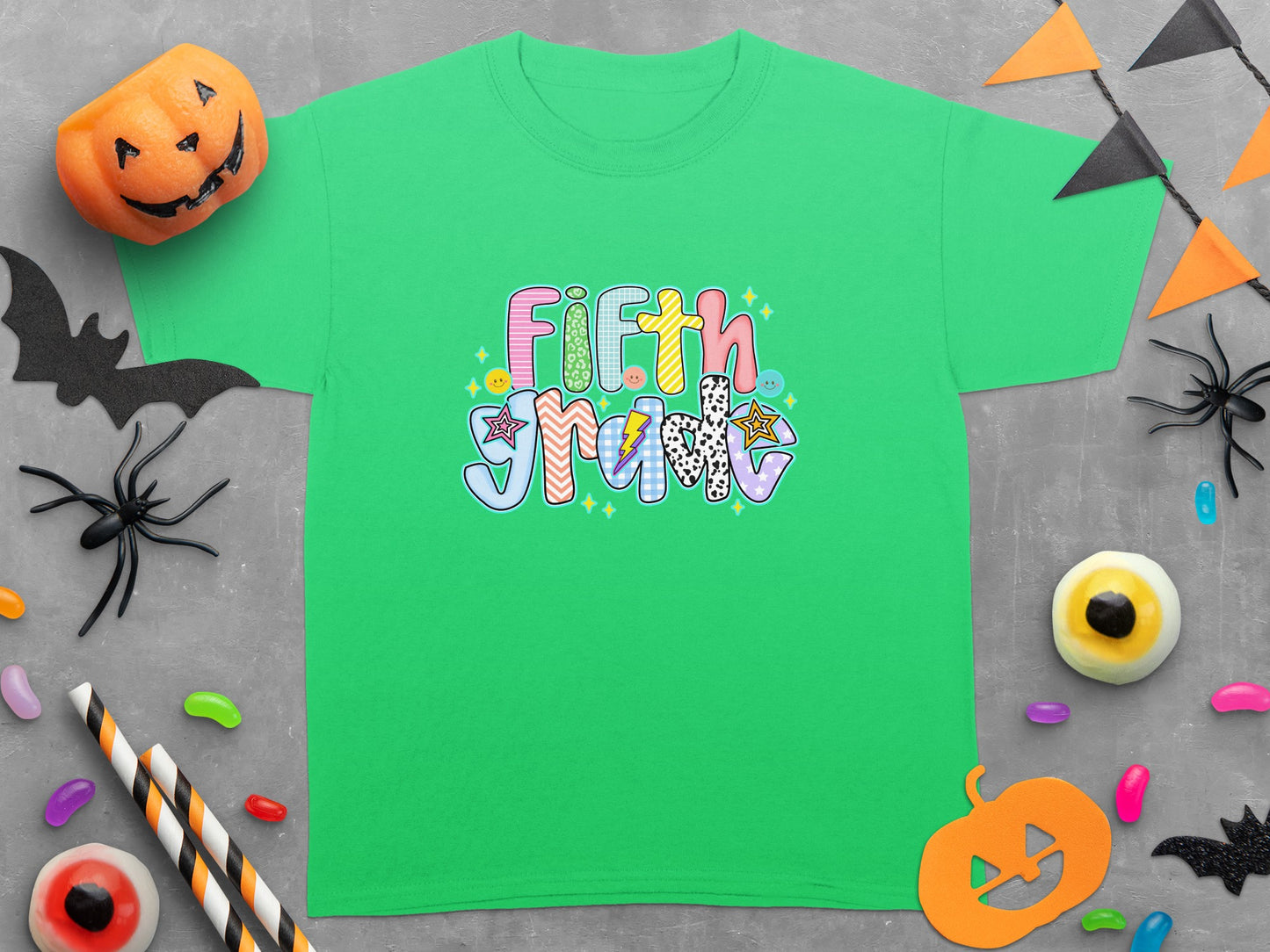 Green t-shirt with "Fifth Grade" text in colorful, patterned letters.