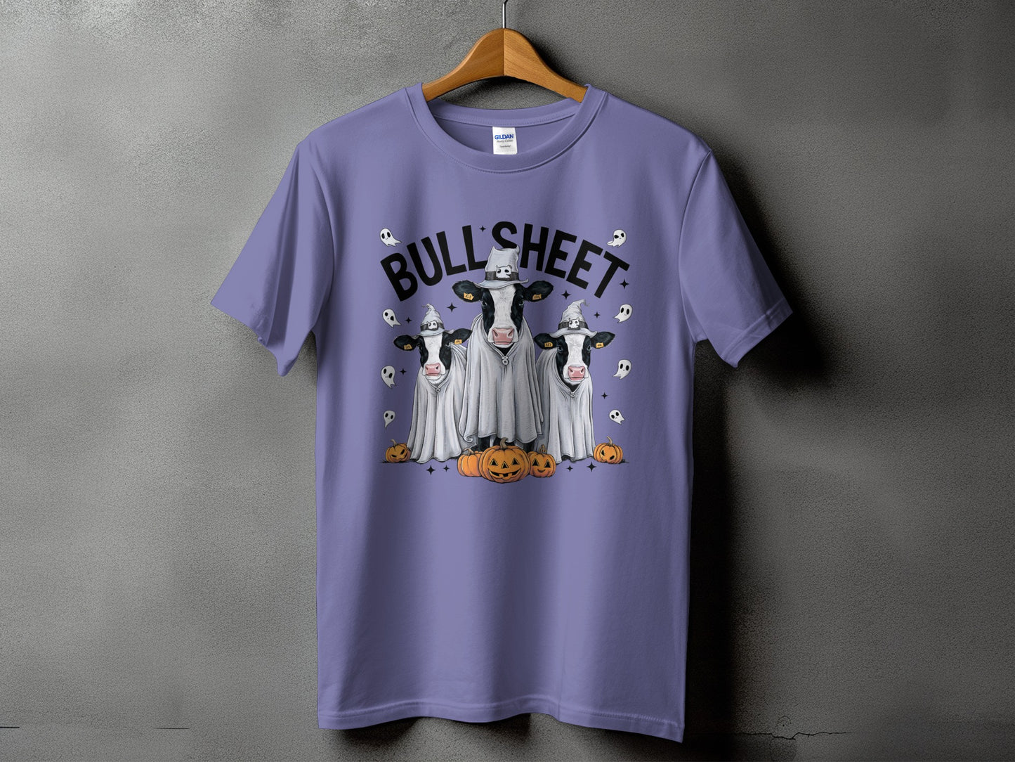 Purple t-shirt with three cows in ghost costumes and pumpkins, reading "BULL'SHEET".