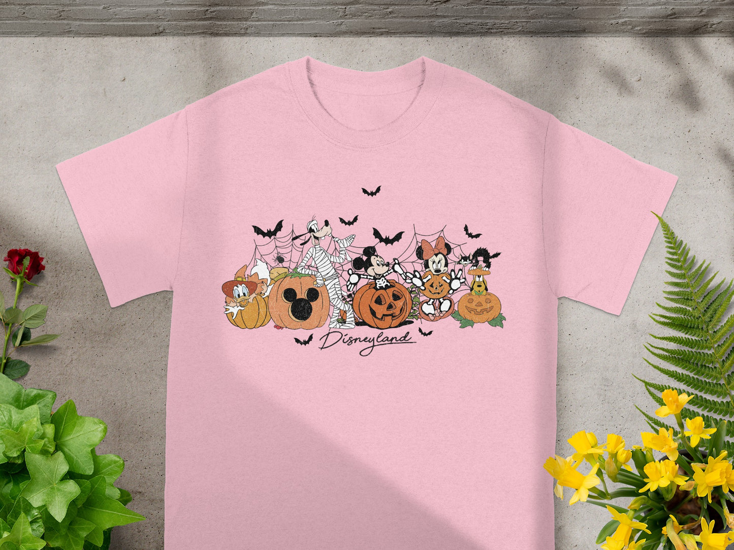 Pink t-shirt with Disney characters and pumpkins, and "Disneyland" text.