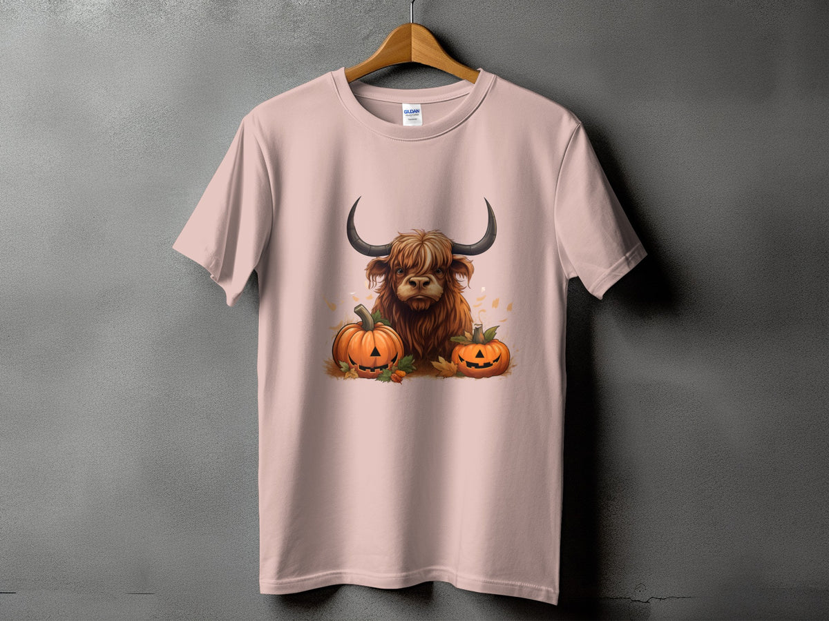Highland cow with pumpkins and fall leaves graphic on a pink t-shirt.