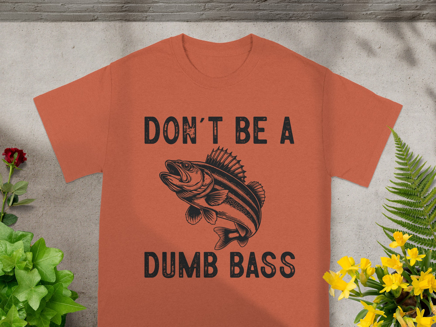 Orange t-shirt with "DON'T BE A DUMB BASS" text and bass fish graphic.