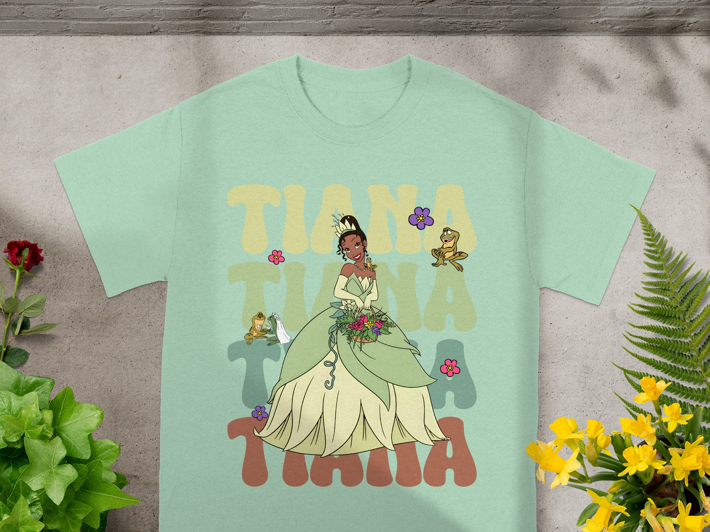 Mint t-shirt with Tiana and frogs graphic.