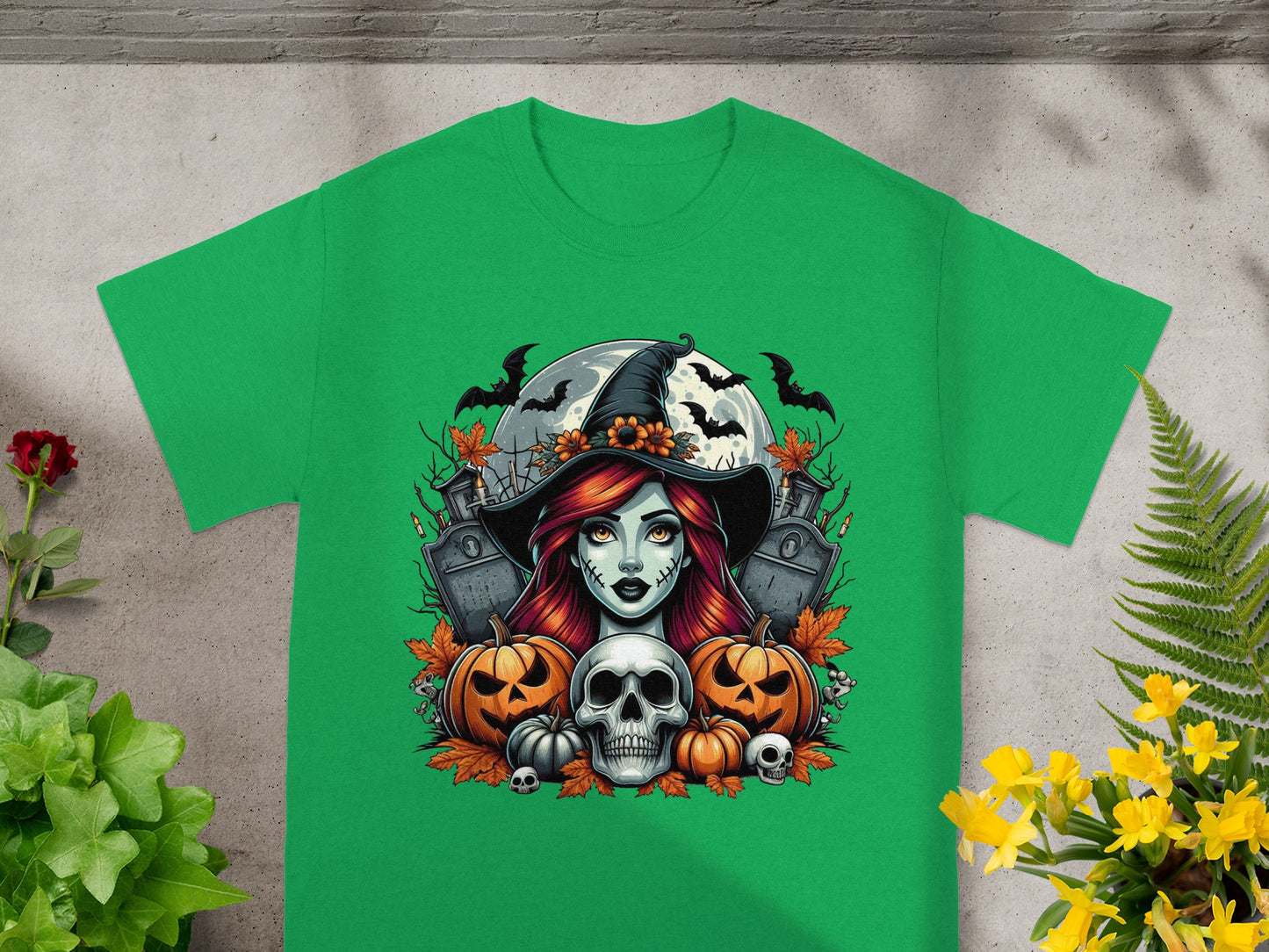 Green t-shirt with a Halloween graphic featuring a witch, pumpkins, skull, and bats.