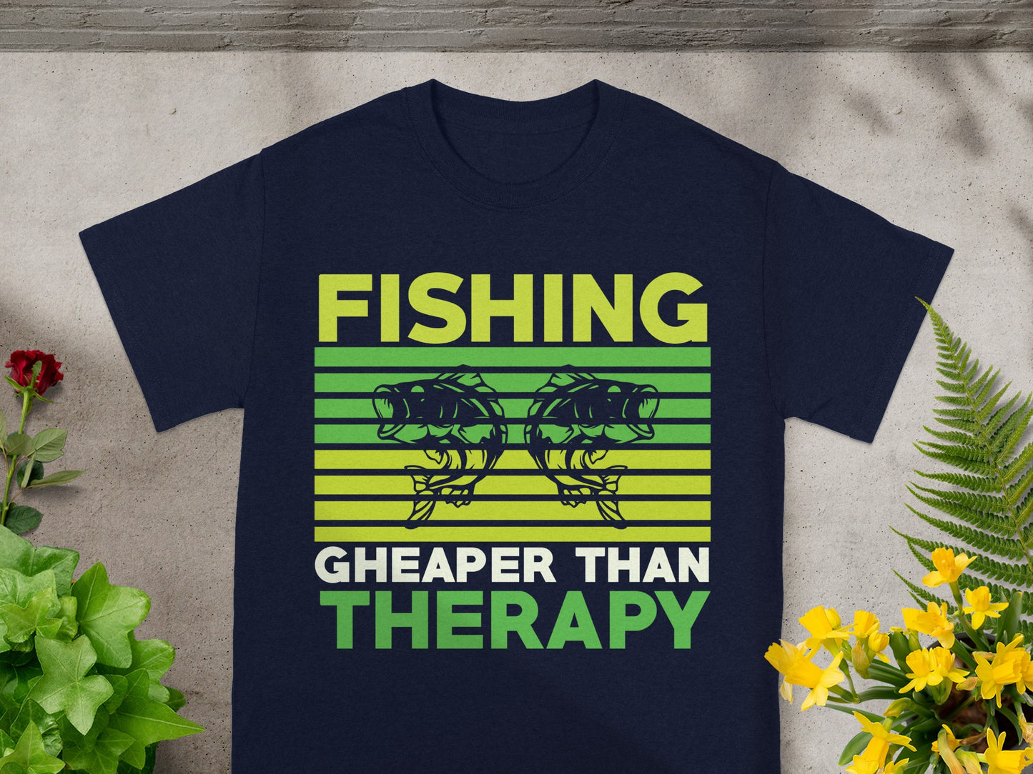 Navy t-shirt with green text that reads "FISHING CHEAPER THAN THERAPY" and two fish.