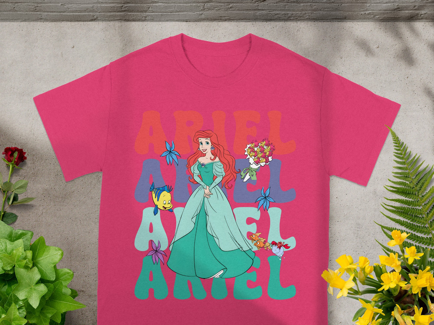 Ariel from The Little Mermaid in a green dress with colorful text.