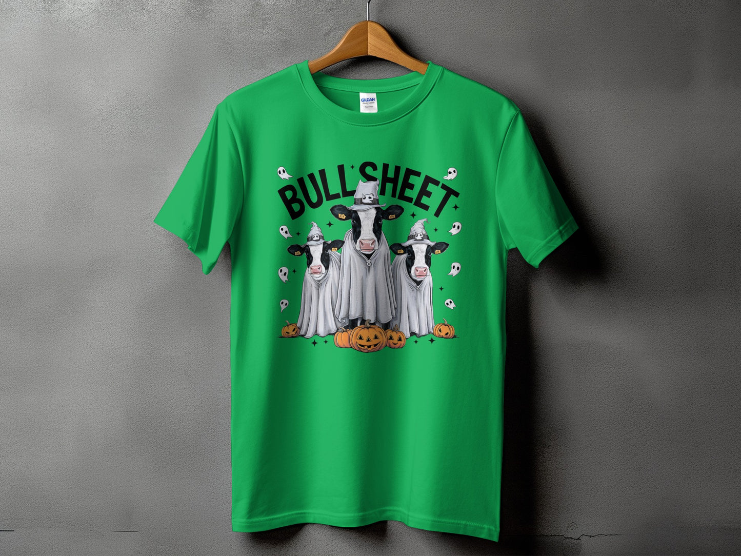 Green t-shirt with three cows dressed as ghosts and wearing witch hats.