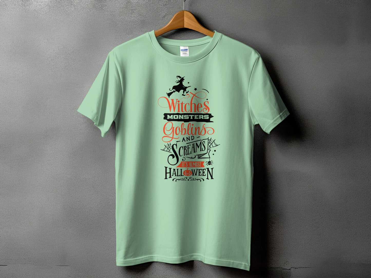 Pale green t-shirt with Halloween graphic: "Witches, Monsters, Goblins, and Screams"