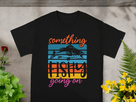 Black t-shirt with "something fishy going on" text and a fish illustration.