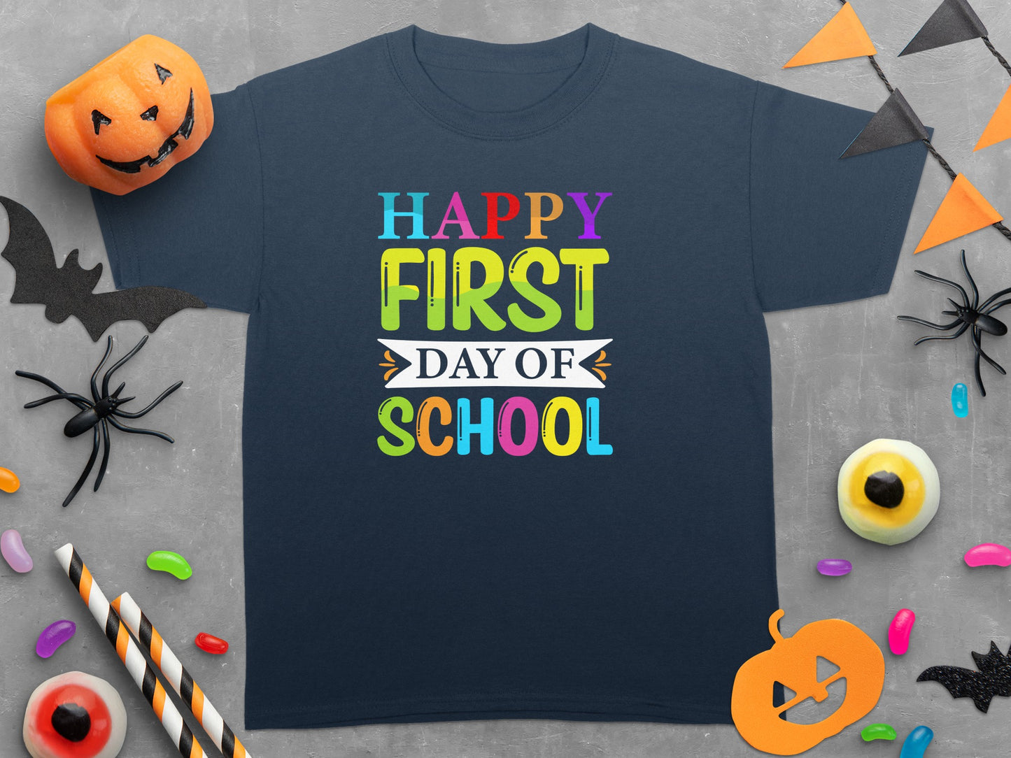 Navy t-shirt with "Happy First Day of School" text and Halloween decorations.