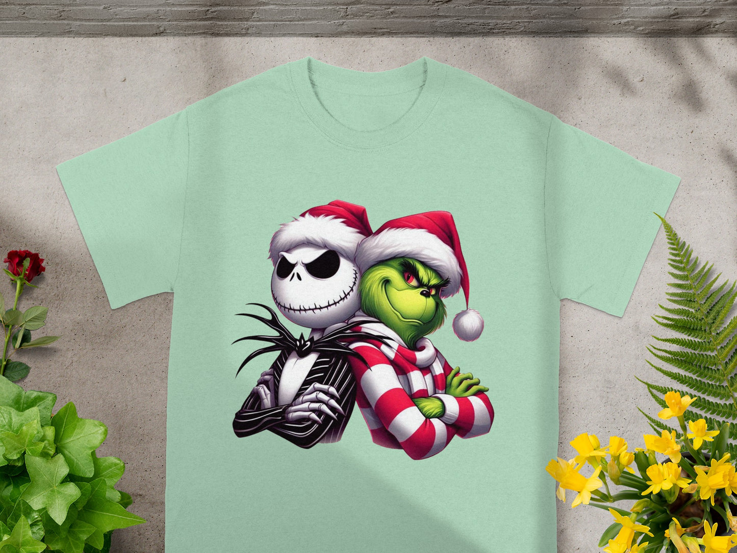 Jack Skellington and the Grinch in Santa hats embrace on a light green t-shirt.
