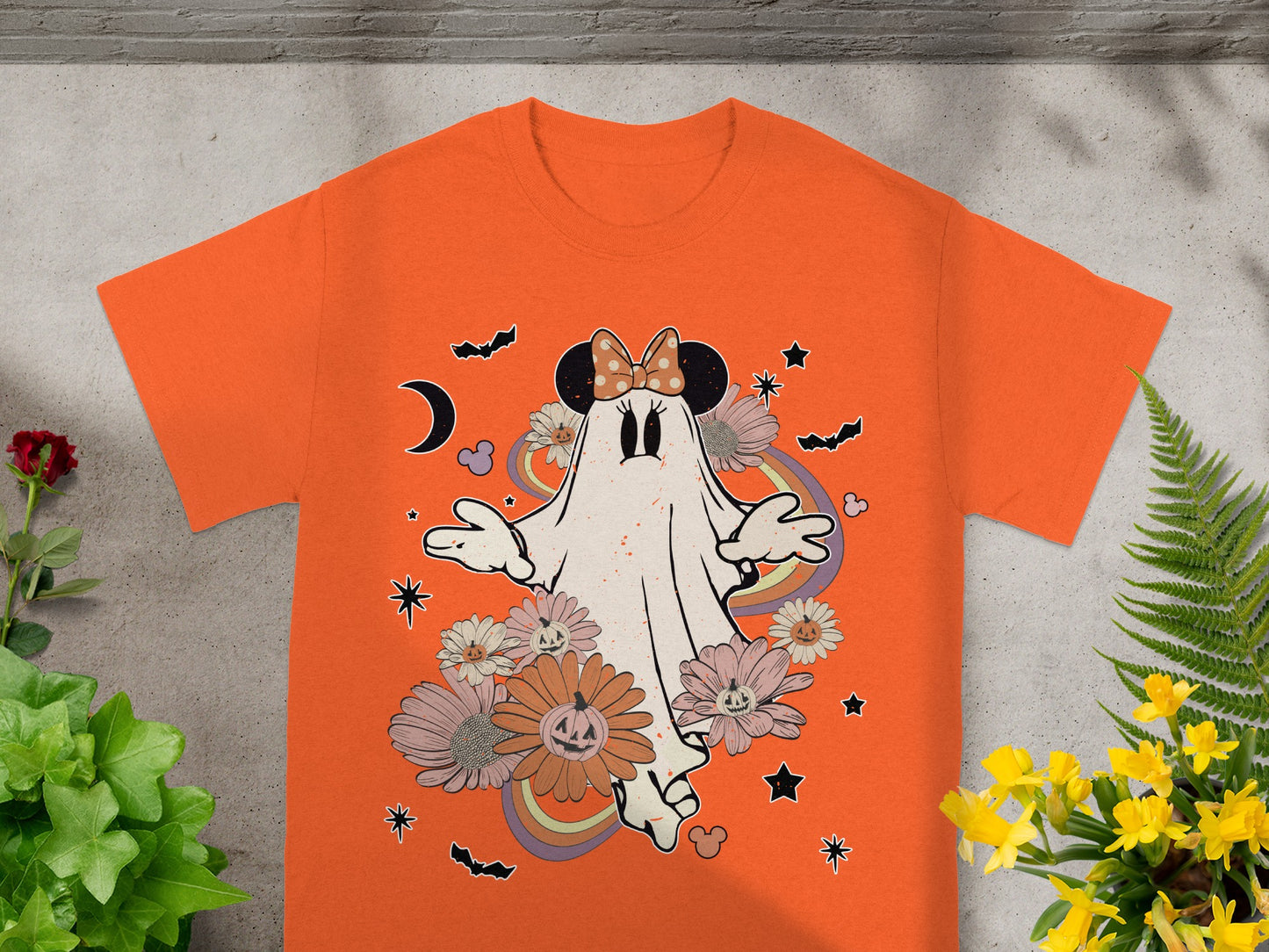 Orange t-shirt with a ghost wearing Mickey ears, flowers, bats, and rainbows.