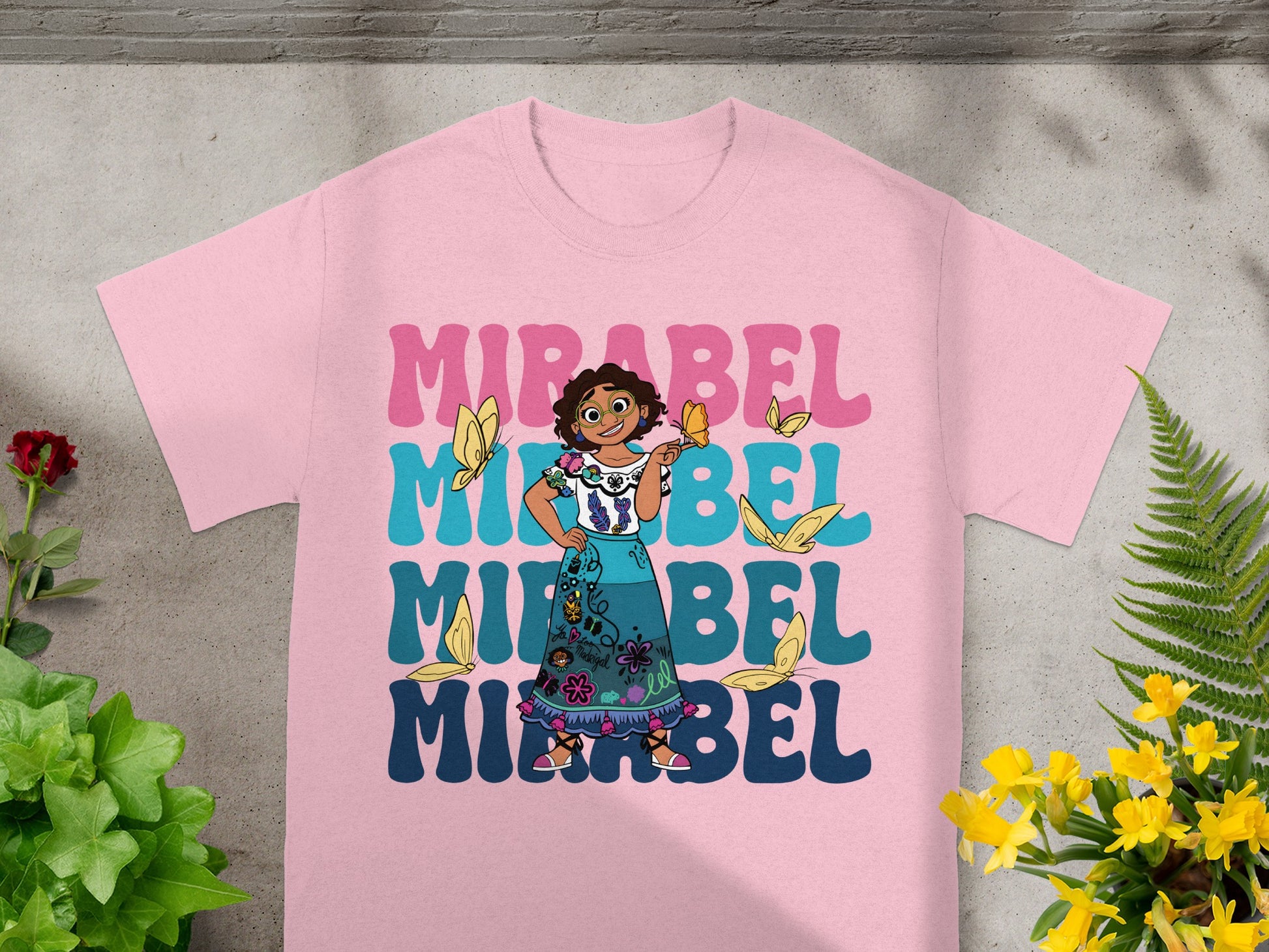 Mirabel from Encanto on a pink t-shirt with butterflies and repeating text.