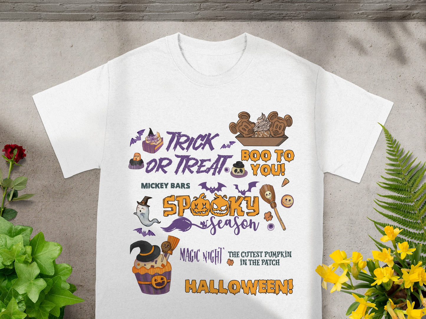 White t-shirt with Halloween graphics including Mickey bars, ghosts, pumpkins, and text.