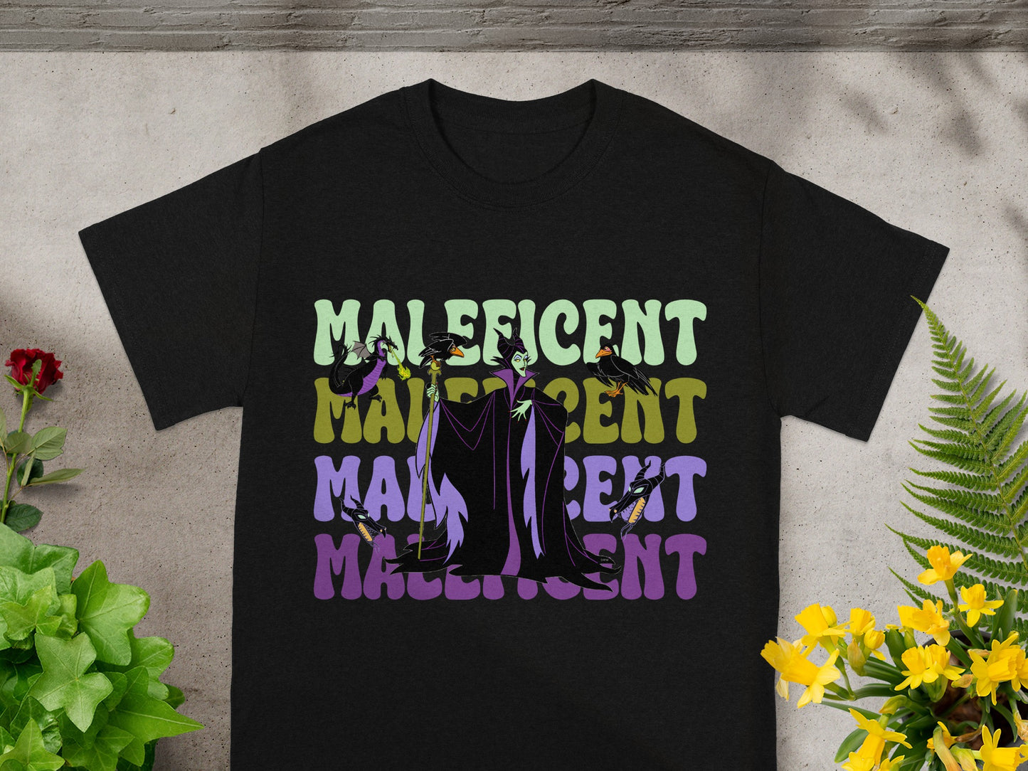 Black t-shirt with "Maleficent" text in colorful, vintage-style lettering.