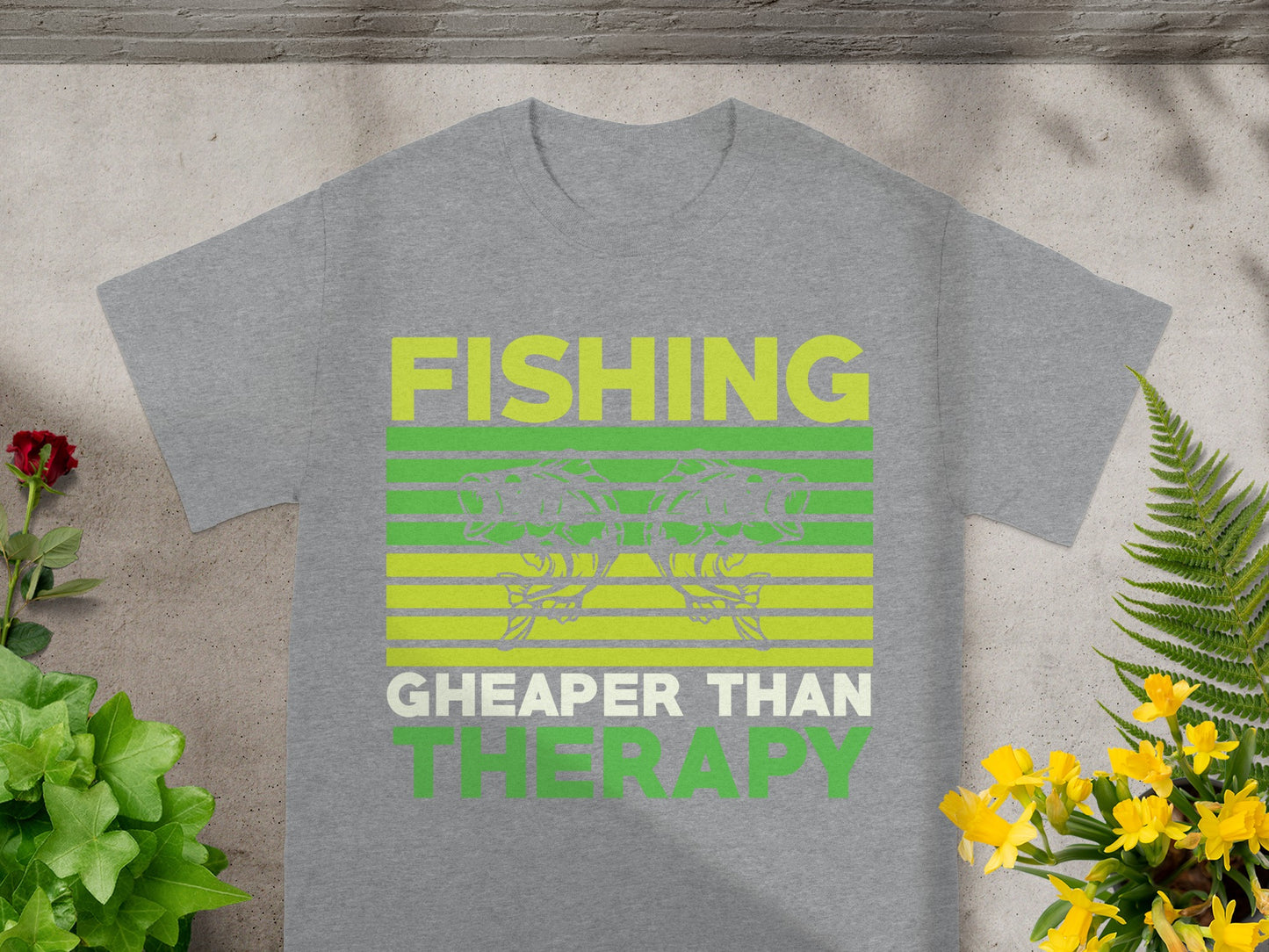 Gray t-shirt with green text that reads "FISHING CHEAPER THAN THERAPY".