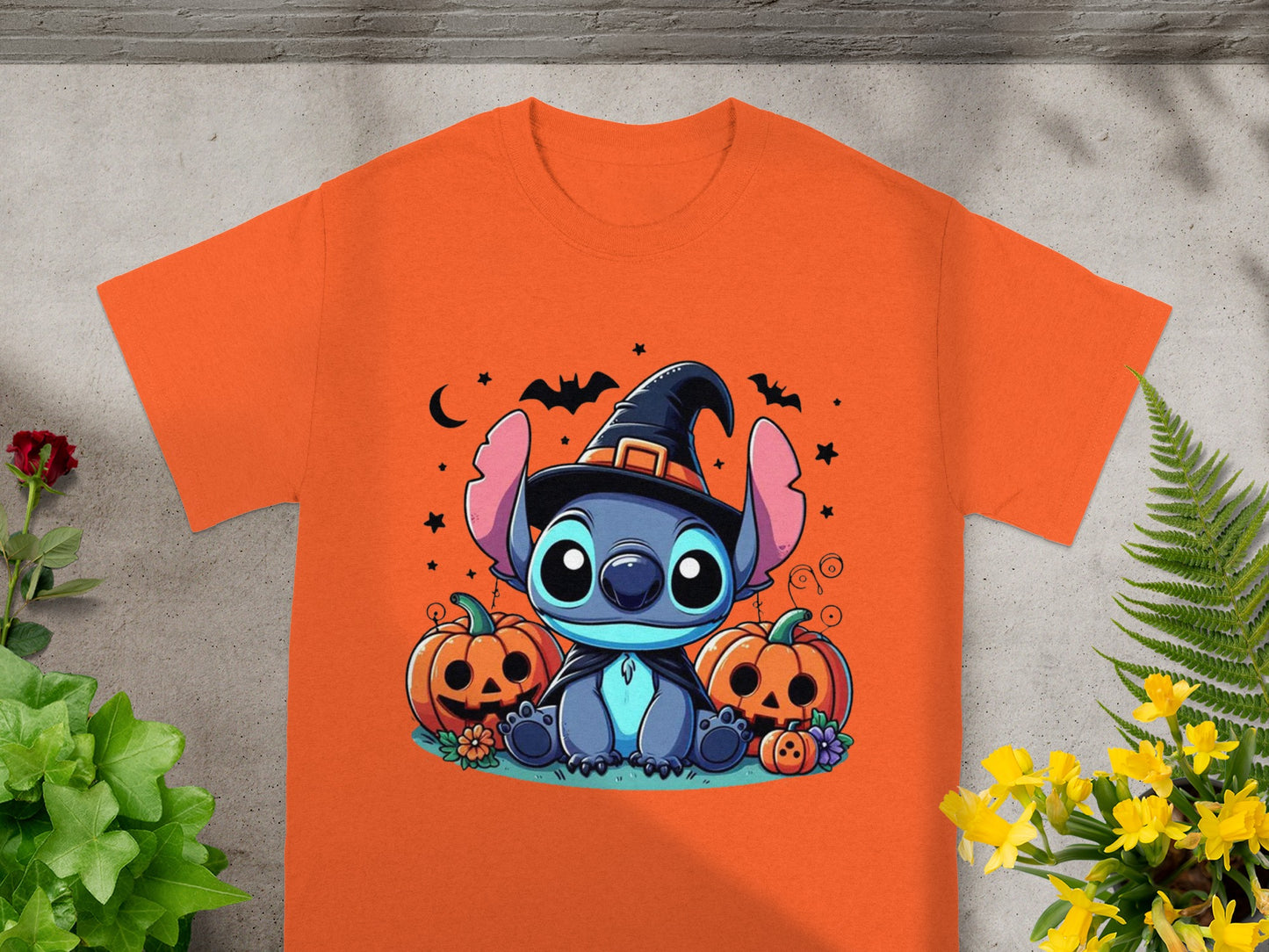 Orange t-shirt with Stitch wearing a witch hat and surrounded by pumpkins.