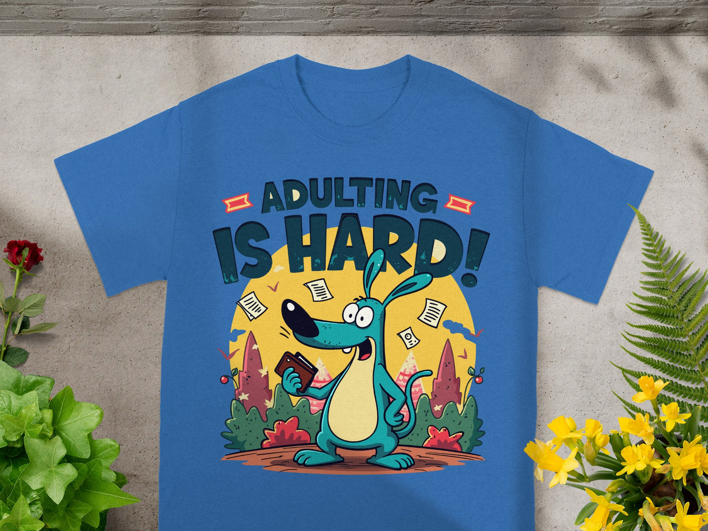 Blue t-shirt with cartoon dog holding wallet and text "ADULTING IS HARD!".