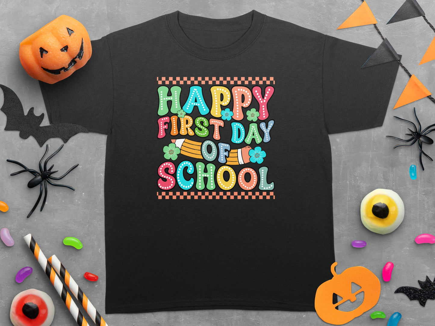 Black t-shirt with "Happy First Day Of School" text in colorful, retro font.