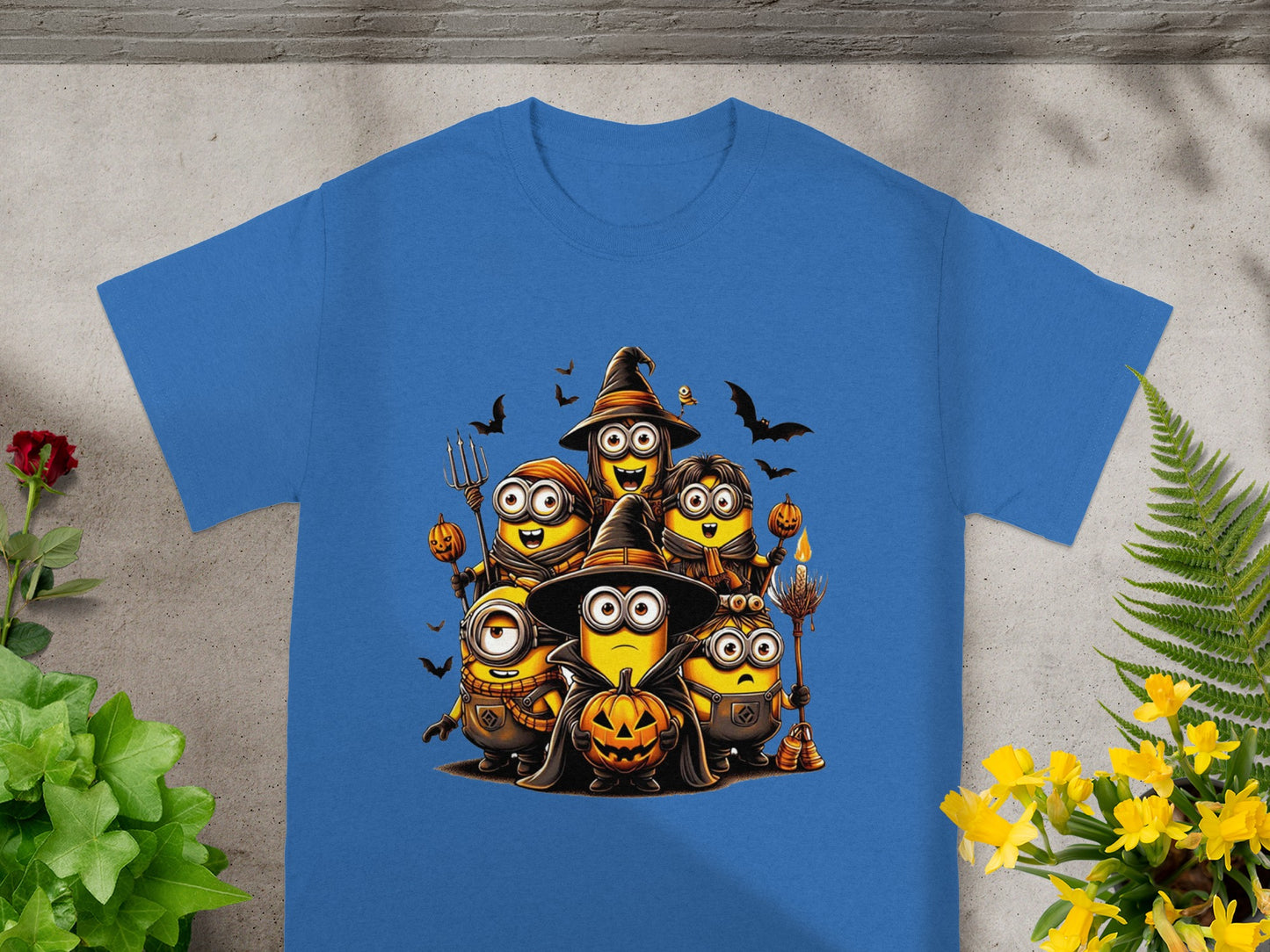 Minions in Halloween costumes with pumpkins and bats, on a blue shirt.