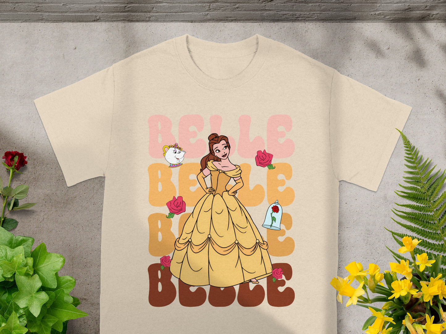 Belle from Beauty and the Beast on a tan t-shirt with flowers.