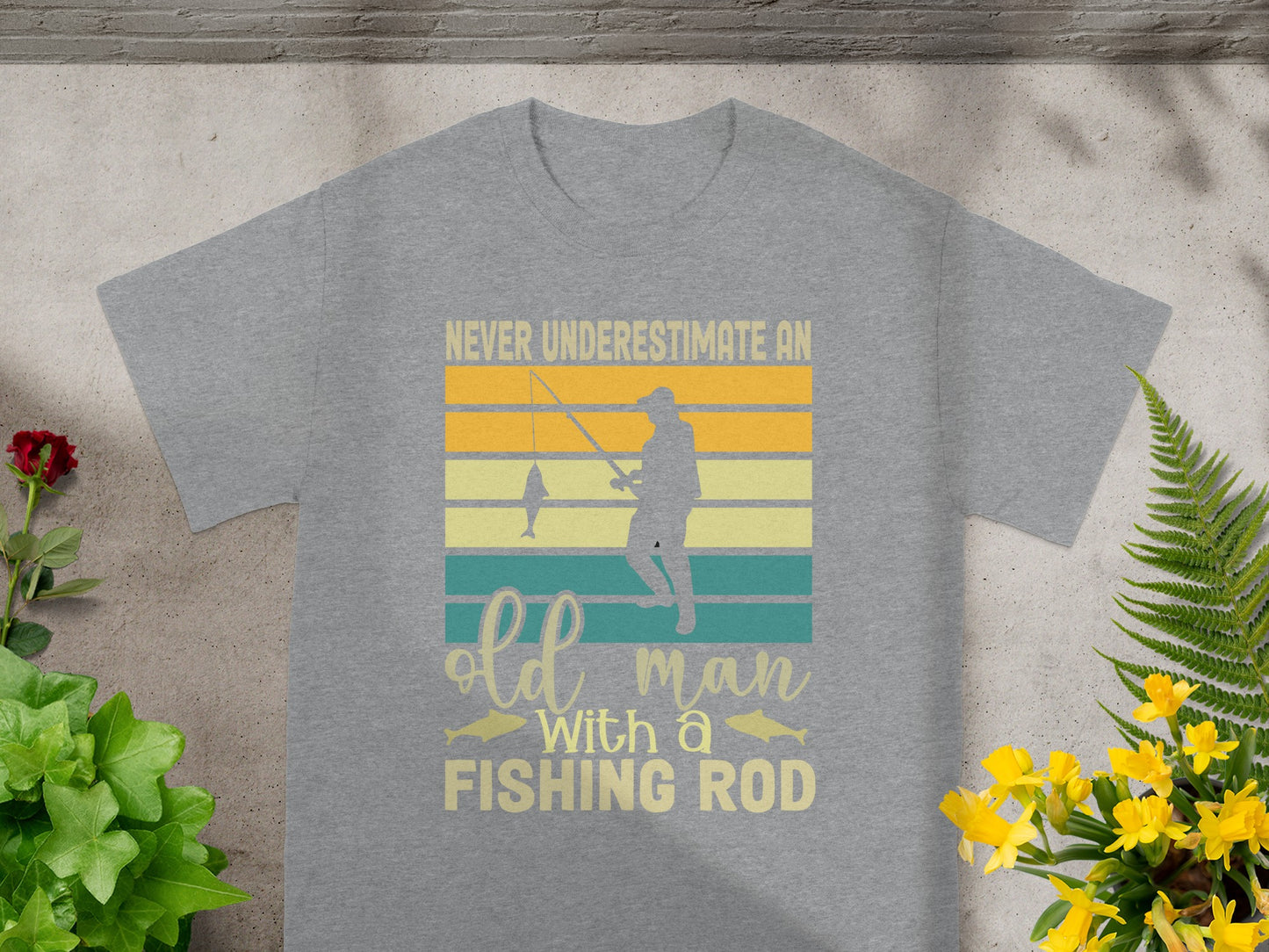 Grey t-shirt with text "Never Underestimate An Old Man With A Fishing Rod".