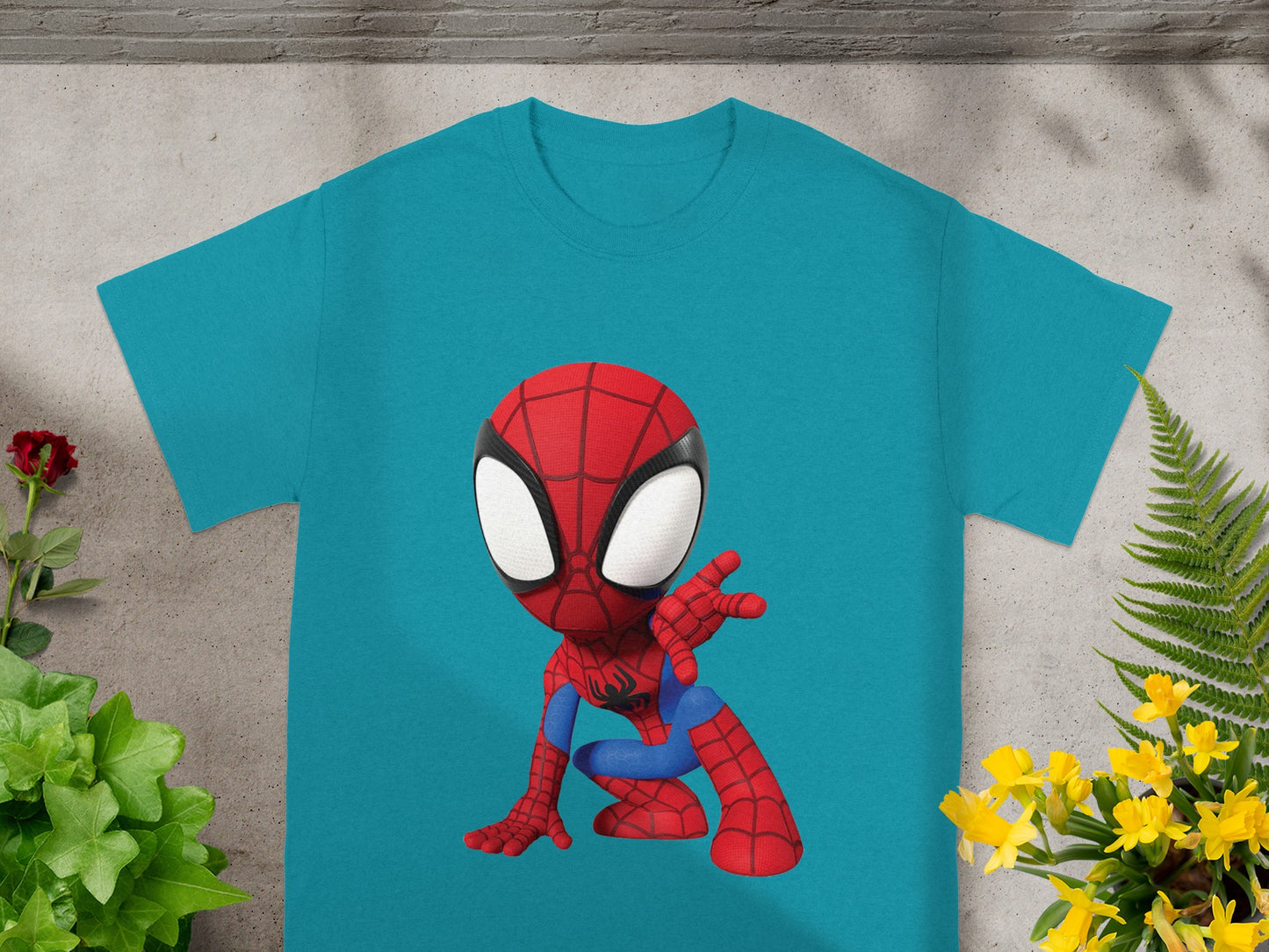 Teal t-shirt with a cartoon Spider-Man graphic in a crouching pose.