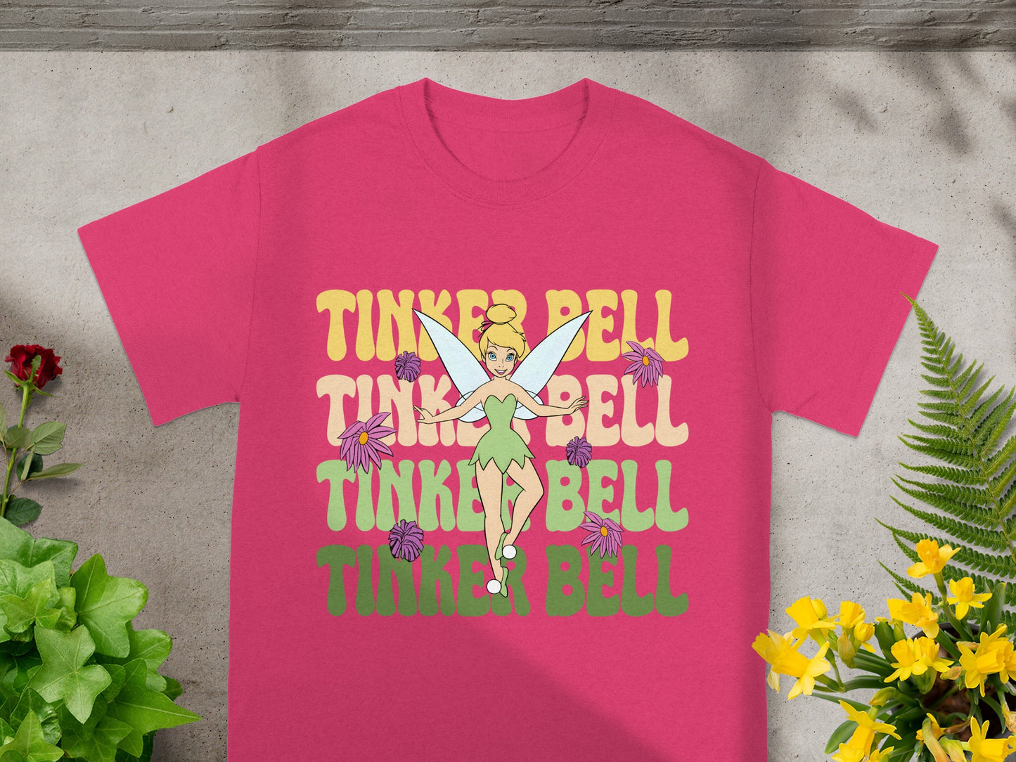 Pink t-shirt with Tinkerbell graphic and colorful text.