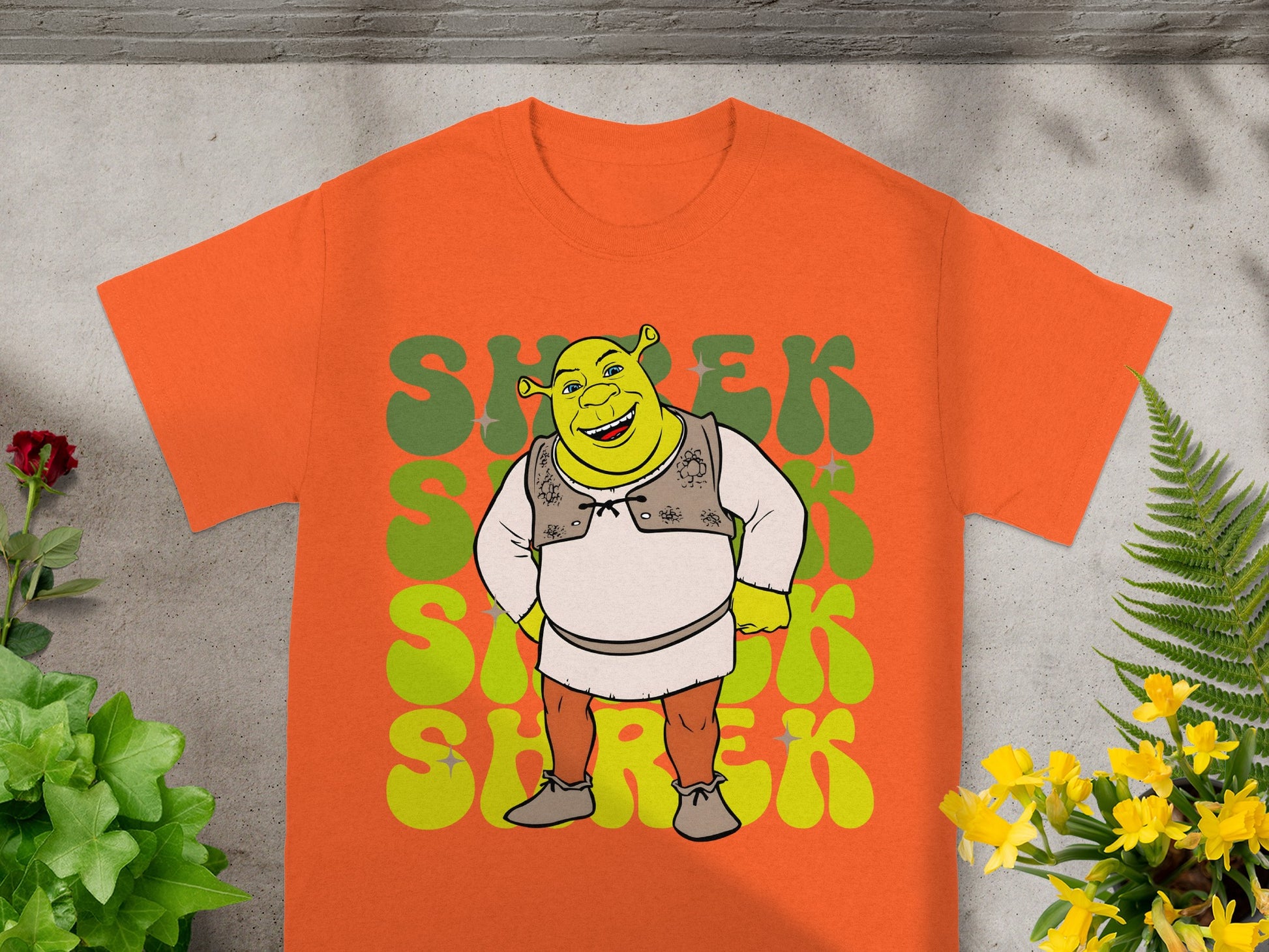 Shrek character graphic on orange t-shirt with green "Shrek" text.