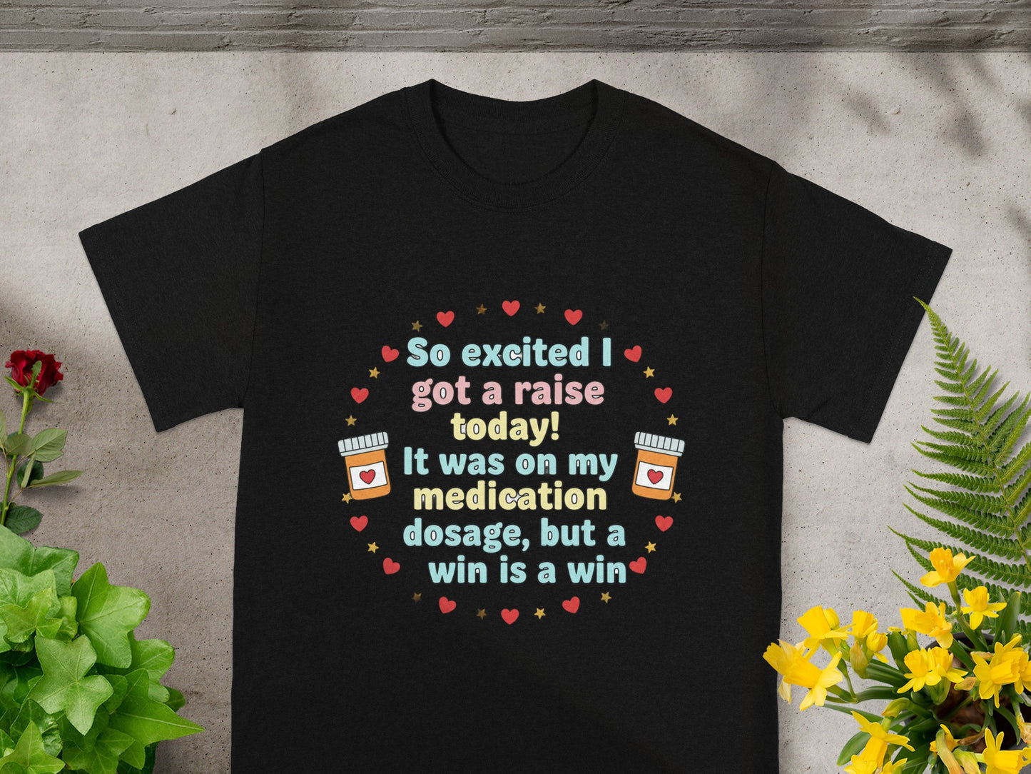 Black t-shirt with text "So excited I got a raise today! It was on my medication dosage, but a win is a win."