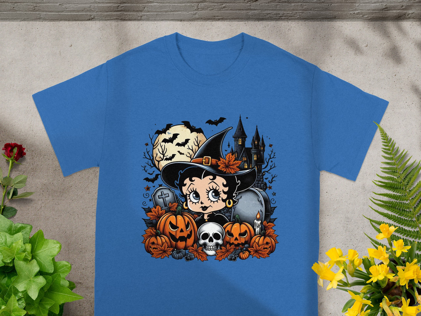 Betty Boop in witch costume with pumpkins, skull, bats, and haunted castle.