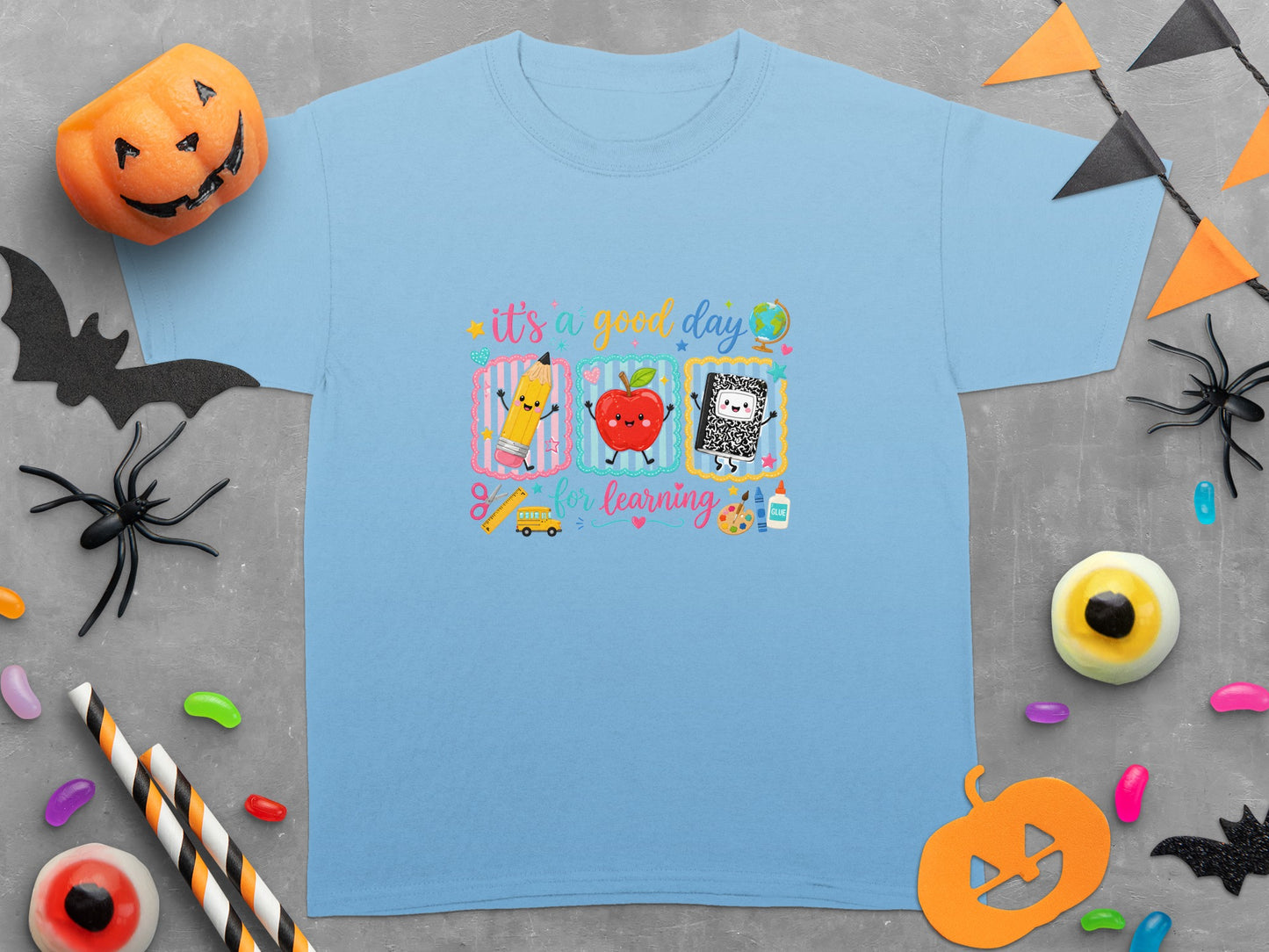 Light blue t-shirt with "it's a good day for learning" and school supplies graphic.