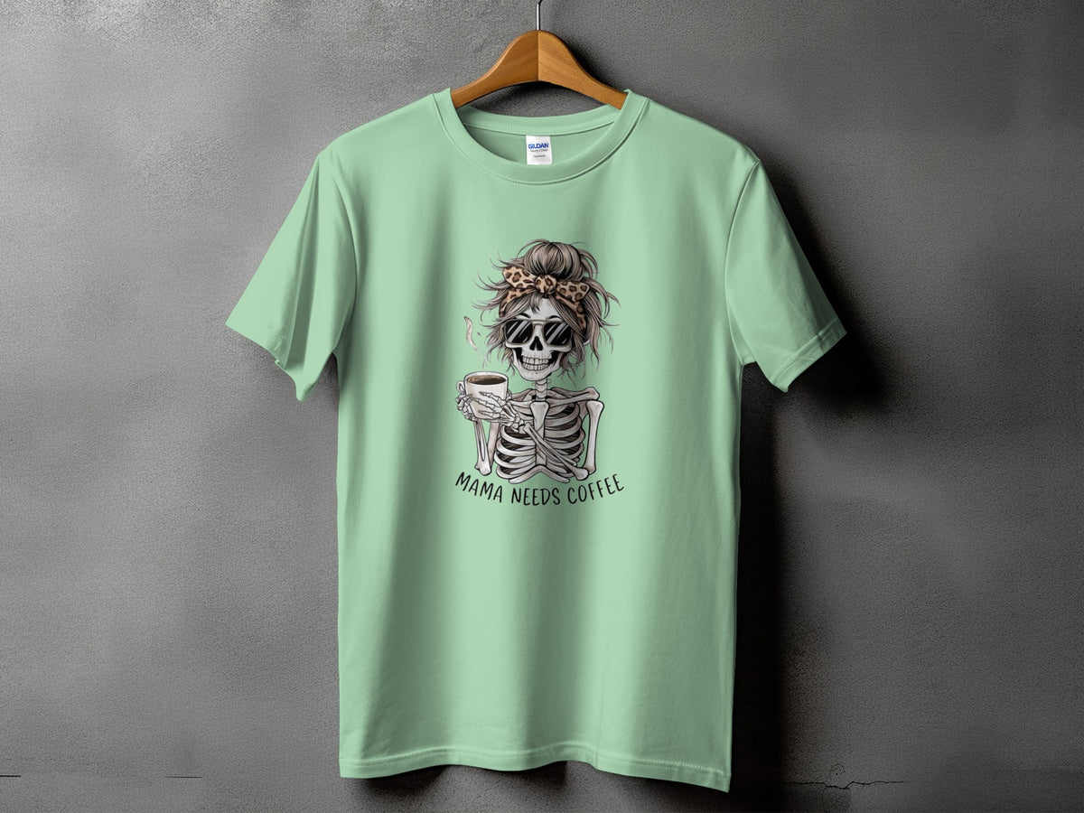 Light green t-shirt with skeleton graphic holding coffee and text "Mama Needs Coffee".