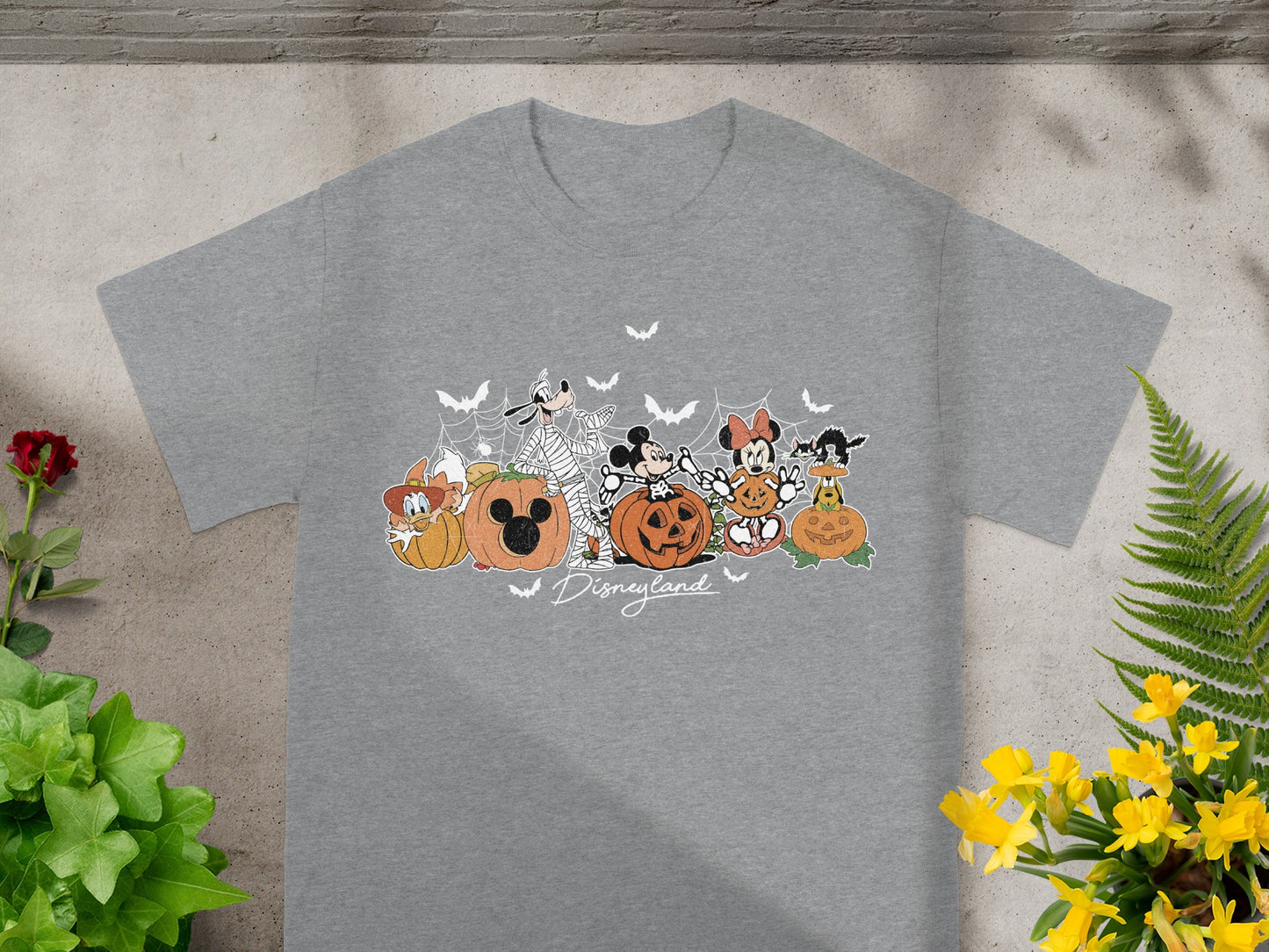 Disneyland Halloween graphic t-shirt with Mickey, Minnie, Goofy, Pluto, and Donald surrounded by pumpkins.