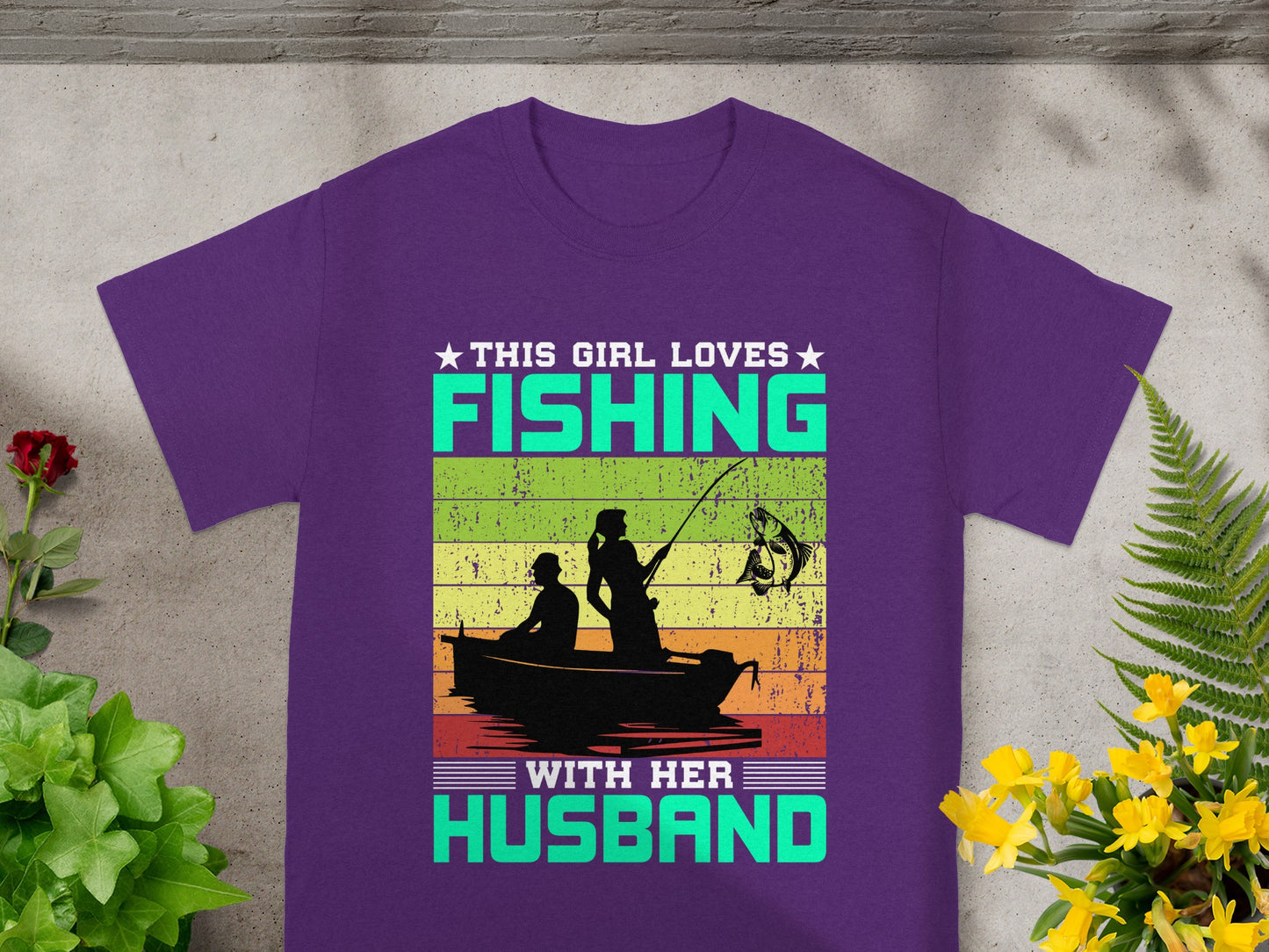 Purple t-shirt with "This Girl Loves Fishing With Her Husband" text and fishing boat graphic.