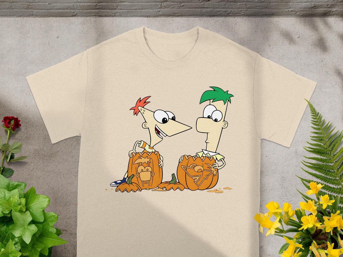 Phineas and Ferb characters with carved pumpkins on a cream t-shirt.