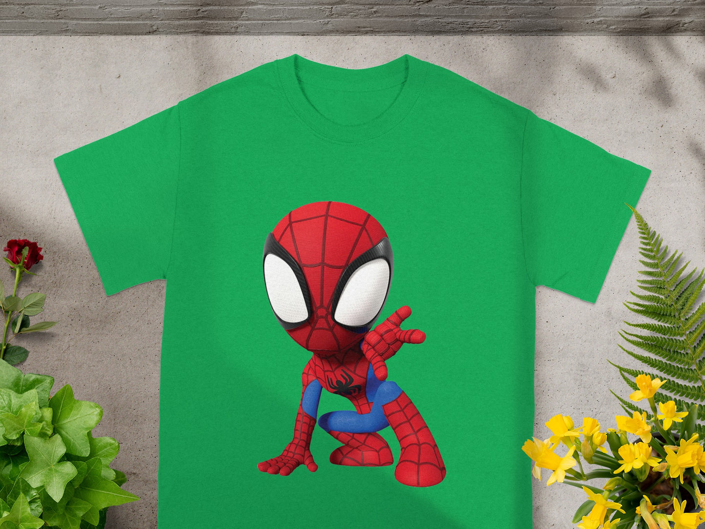 Chibi Spider-Man graphic on a green t-shirt with plants and flowers.