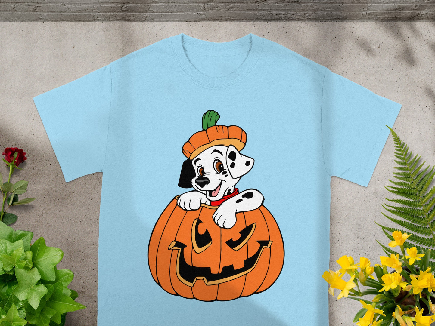 Light blue t-shirt with a cartoon Dalmatian puppy peeking out of a jack-o'-lantern.