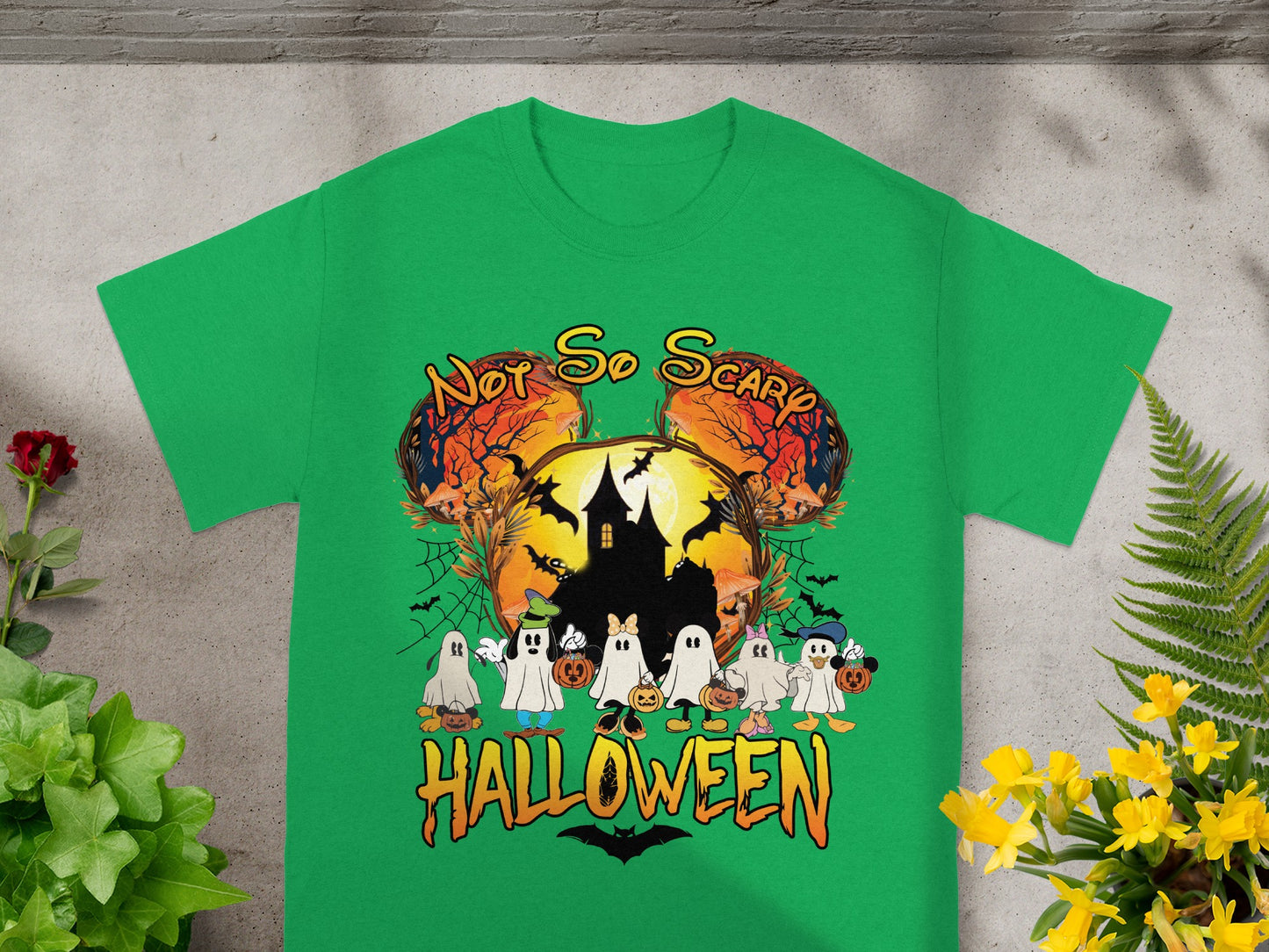 Green t-shirt with Halloween graphic featuring ghosts, haunted house, and "Not So Scary Halloween" text.