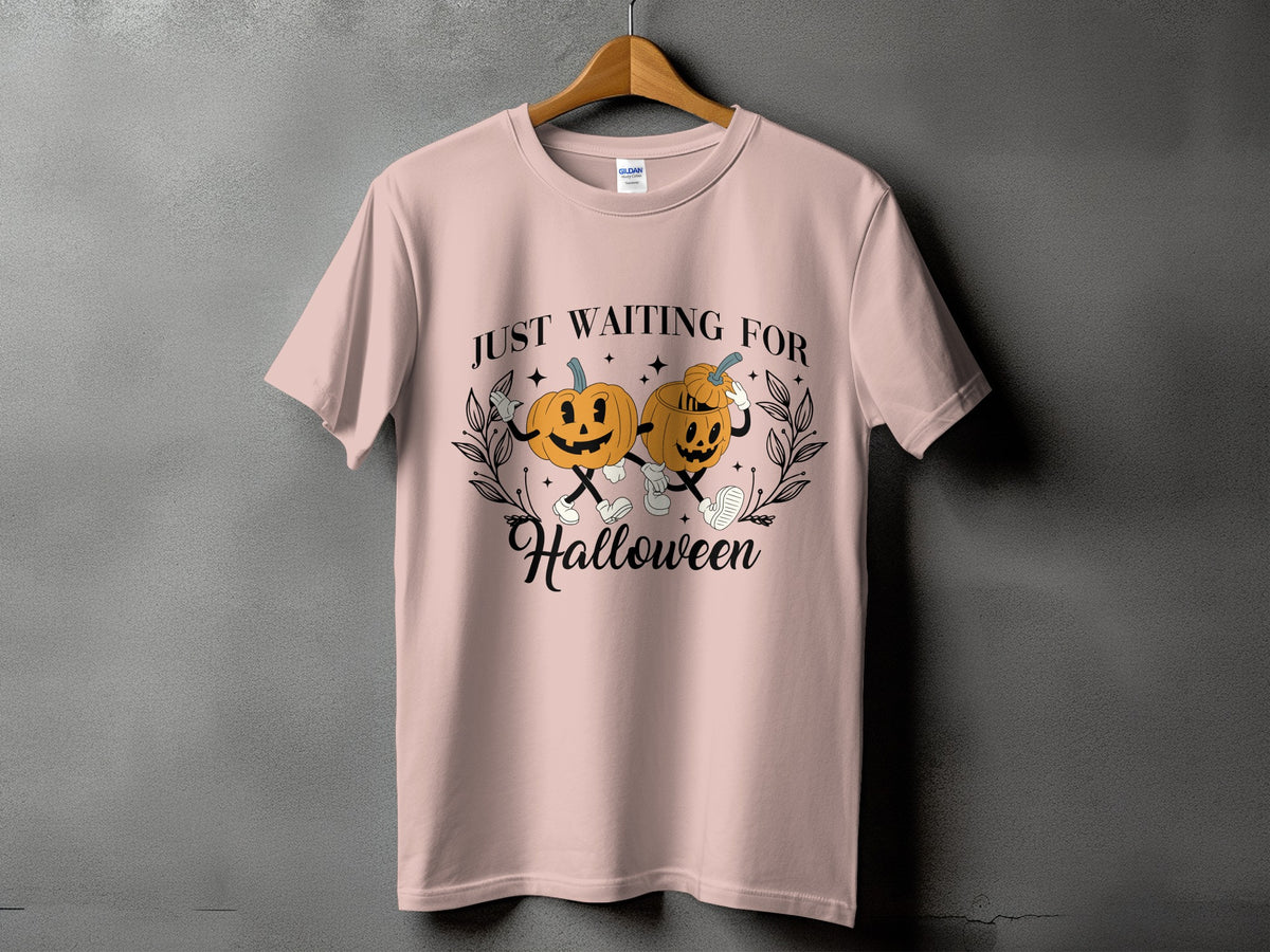 Pink t-shirt with cartoon pumpkins saying "Just Waiting For Halloween."