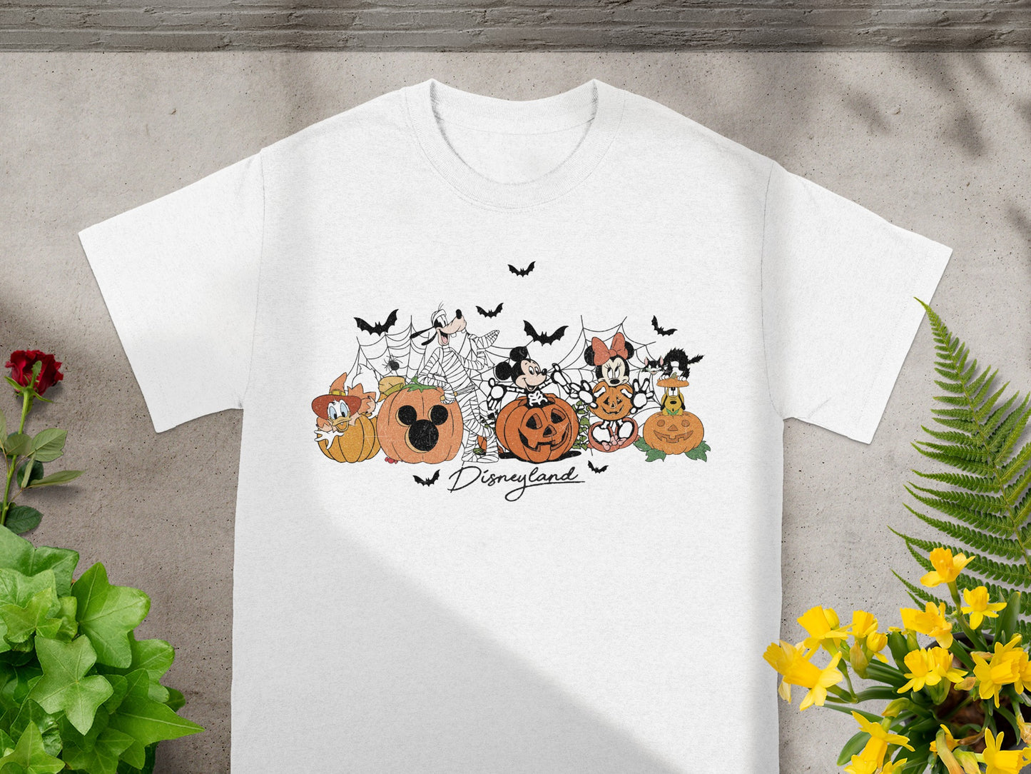 White t-shirt with Disney characters in Halloween costumes with pumpkins and bats.