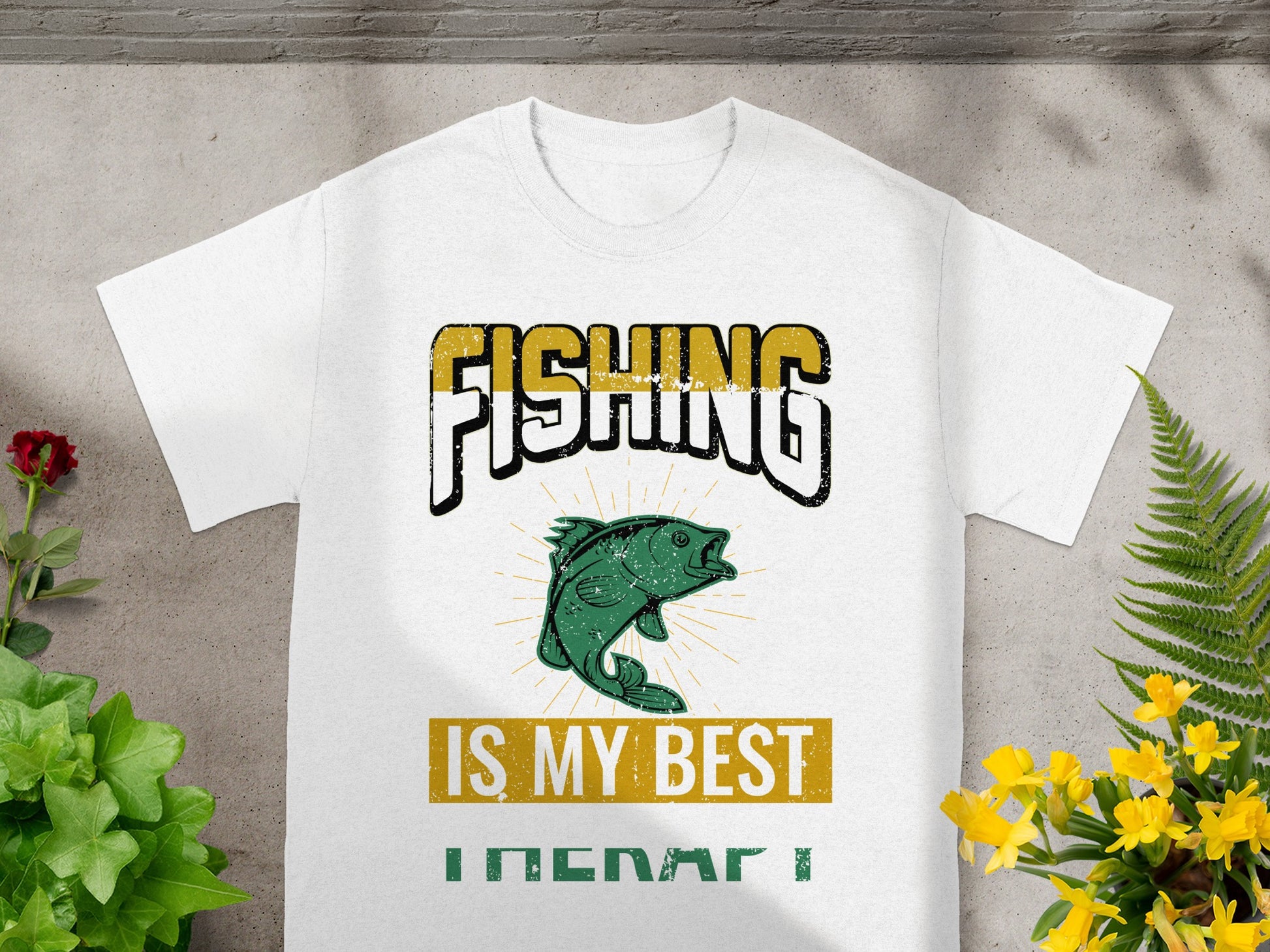 White t-shirt with text "FISHING IS MY BEST THERAPY" and a green fish graphic.