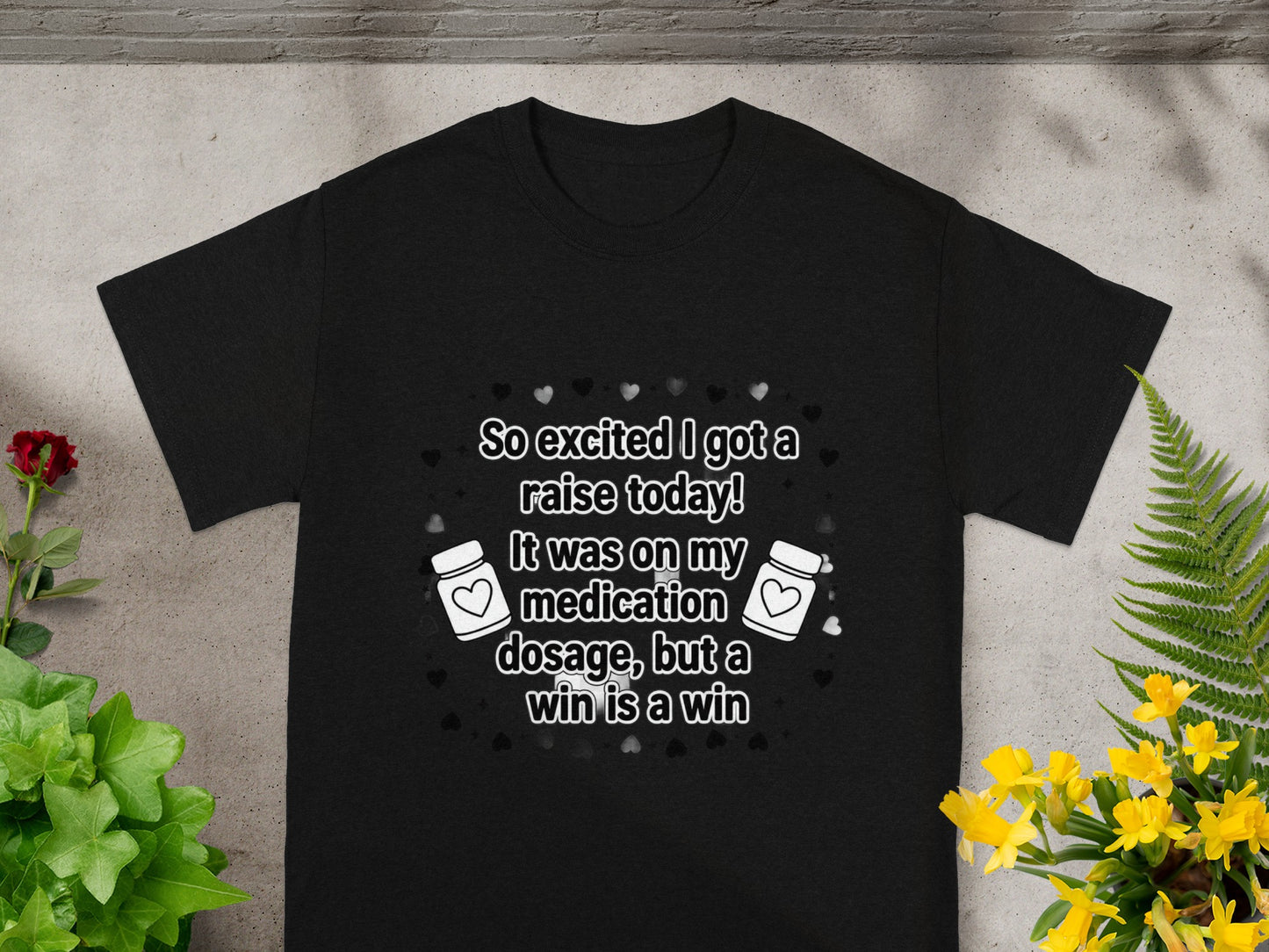 Black t-shirt with text: "So excited I got a raise today! It was on my medication dosage, but a win is a win".