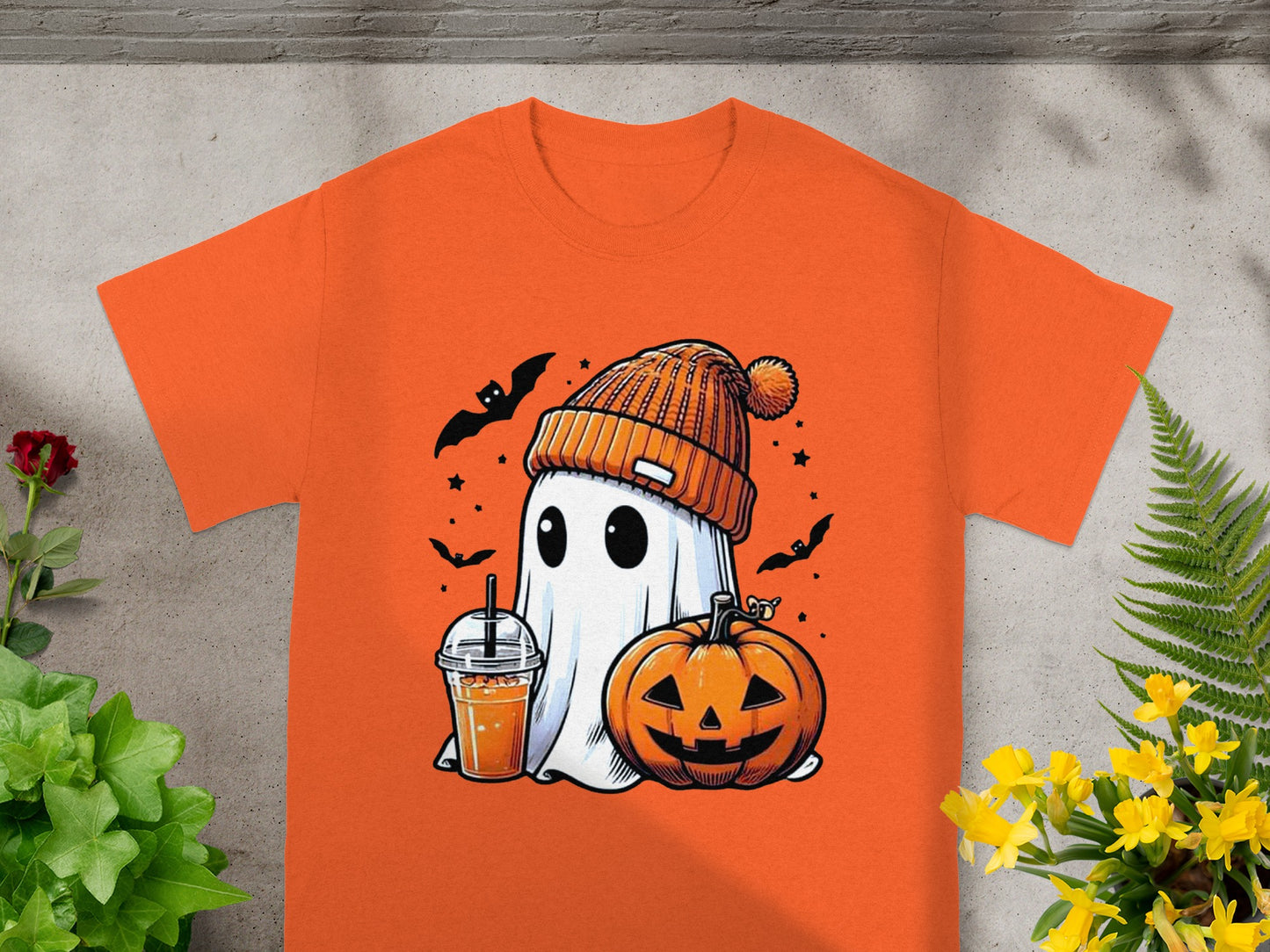 Ghost in beanie with pumpkin and drink on orange t-shirt.