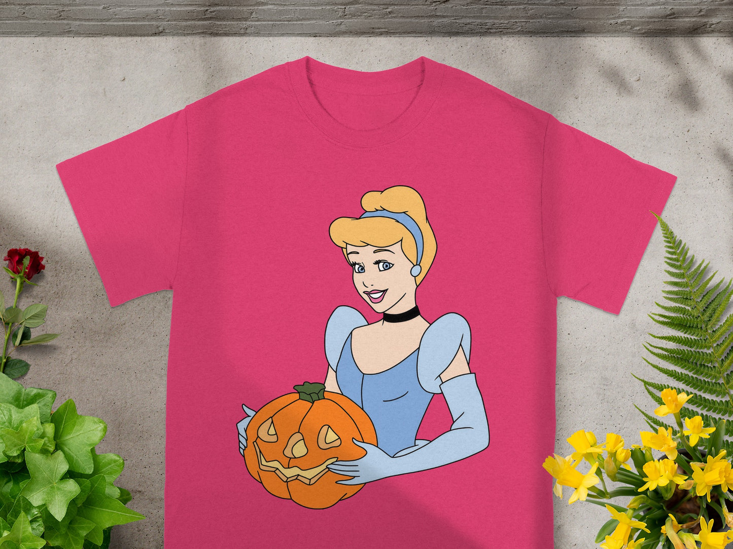 Cinderella holding a jack-o'-lantern on a pink t-shirt.