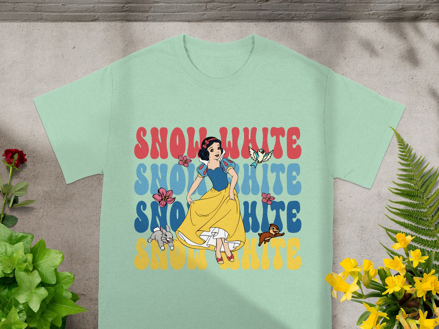 Snow White graphic on mint t-shirt with floral accents.