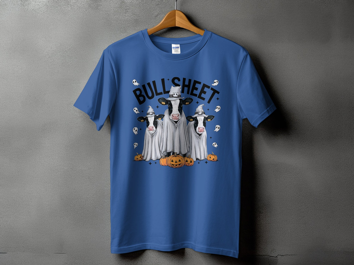 Blue t-shirt with three cows in ghost costumes and pumpkins, text reads "BULL SHEET".