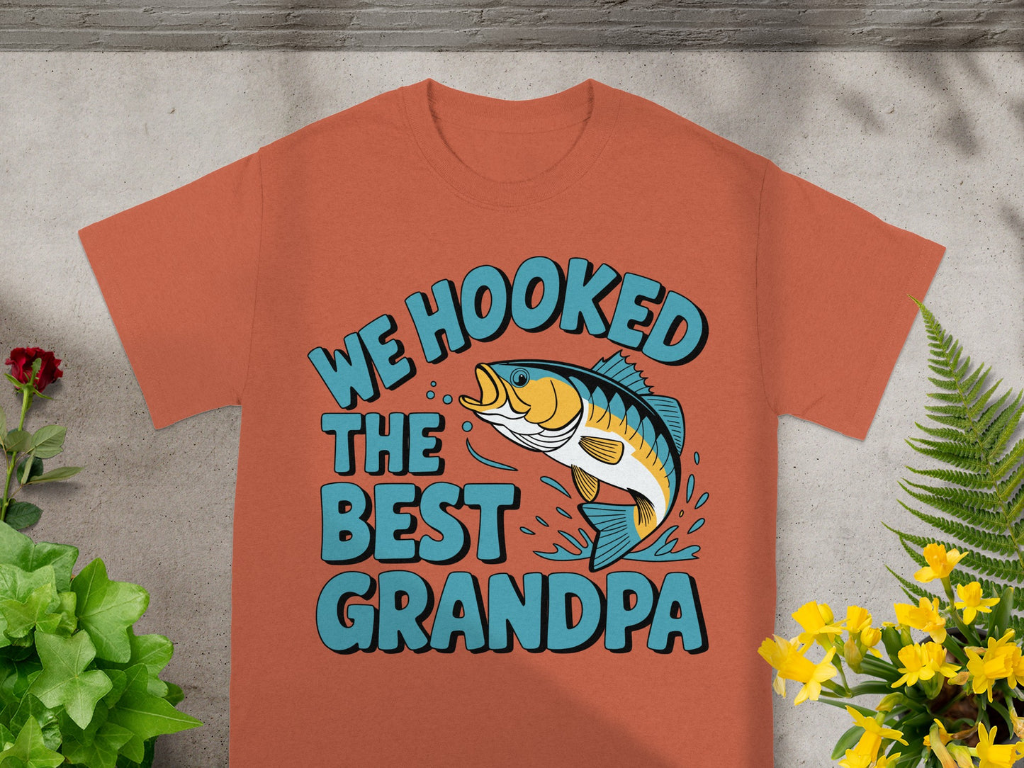 Orange t-shirt with text "We Hooked The Best Grandpa" and a fish graphic.