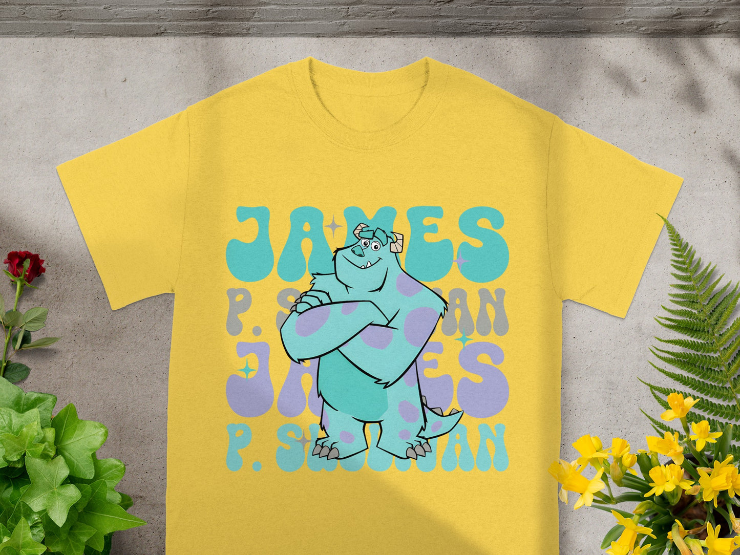 Yellow t-shirt with "James P. Sullivan" in blue and purple lettering.