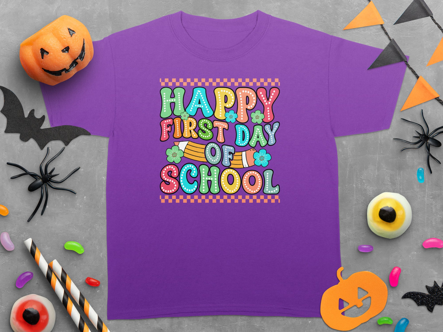 Purple t-shirt with "Happy First Day of School" text and Halloween decorations.